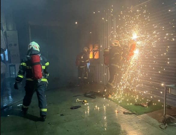 辦公室內5名移工原試圖自行撲滅，但火勢過大，後通報消防人員破門灌救。（翻攝畫面）