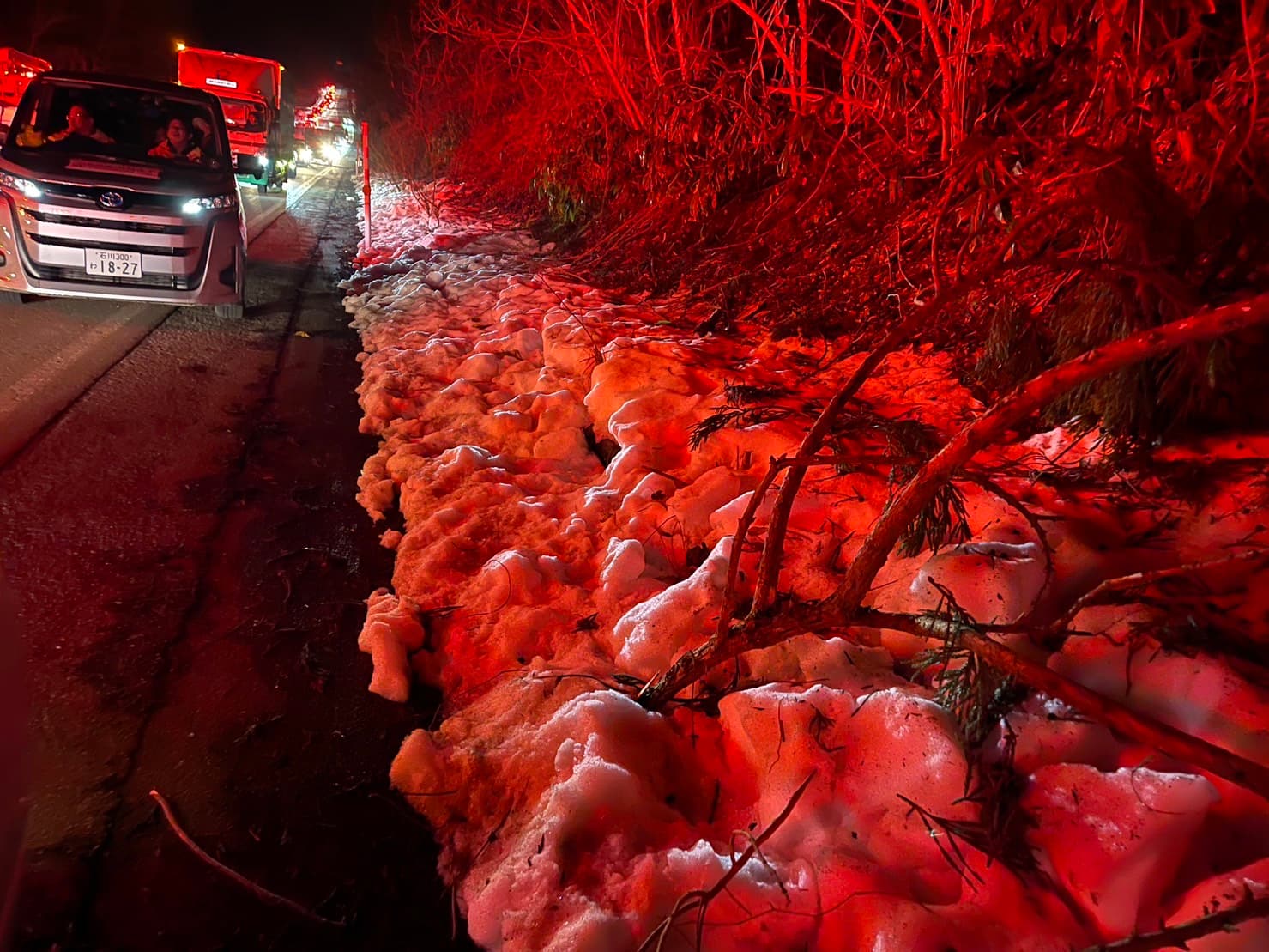 路邊白雪在車陣煞車燈、救護車警示燈的照映下，猶如血染的丰采。