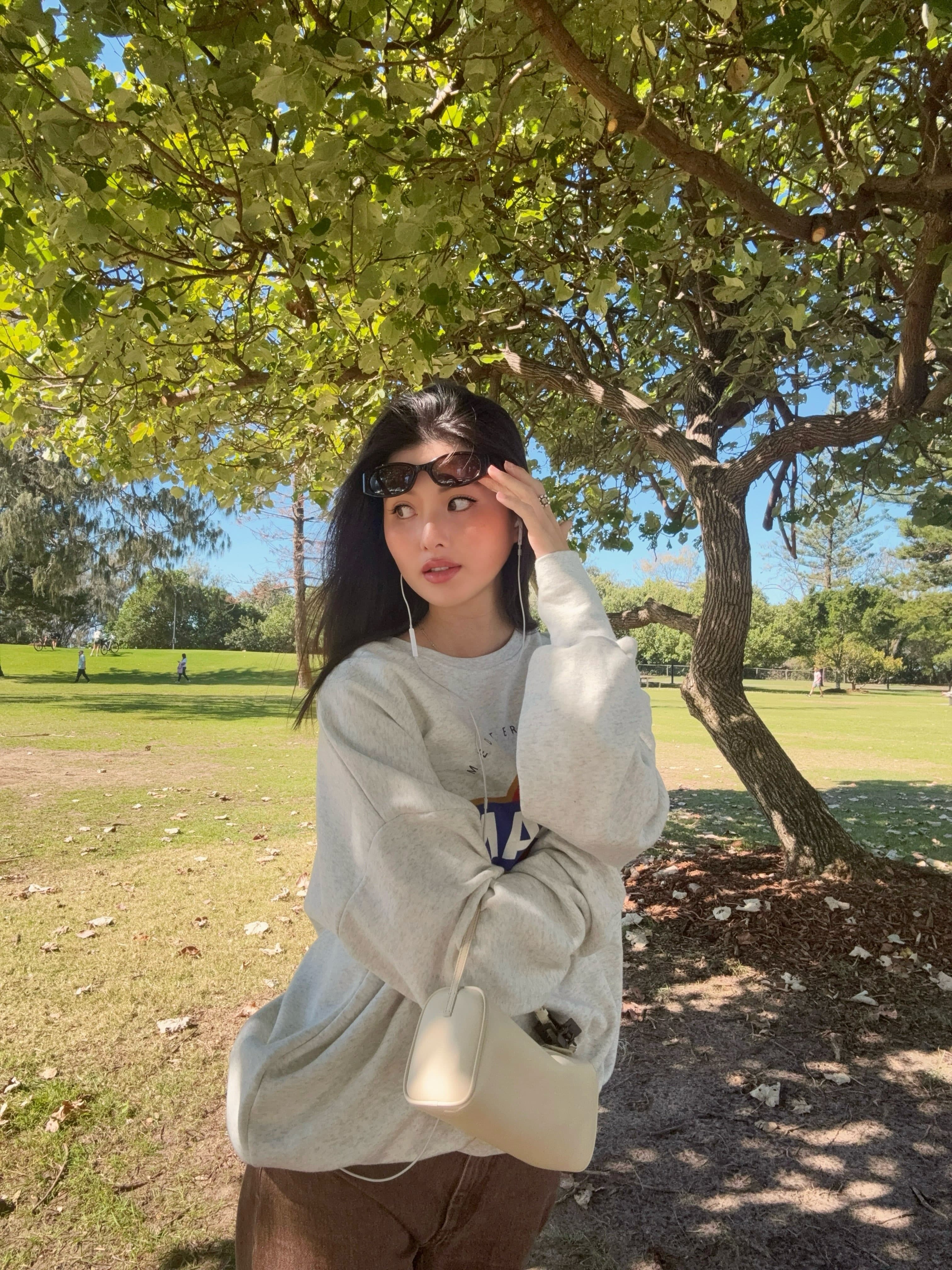廖思惟換上休閒大學T與寬鬆長褲，肩背白色The Row 90's Bag。（翻攝trinityliao IG）