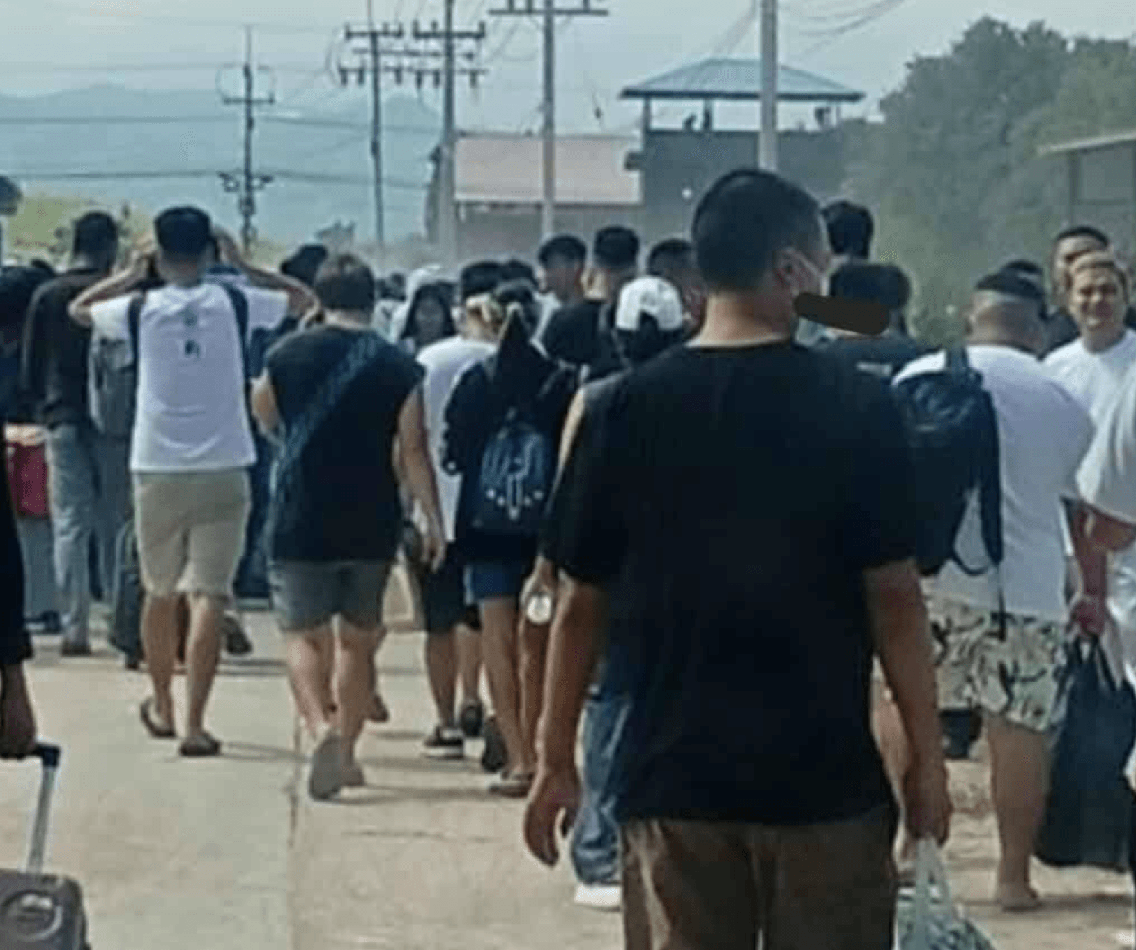 逃離人潮沿著道路湧出園區，許多人背著包包、拉著行李，隊伍綿延不絕。（翻攝X@OoKoLinn3）