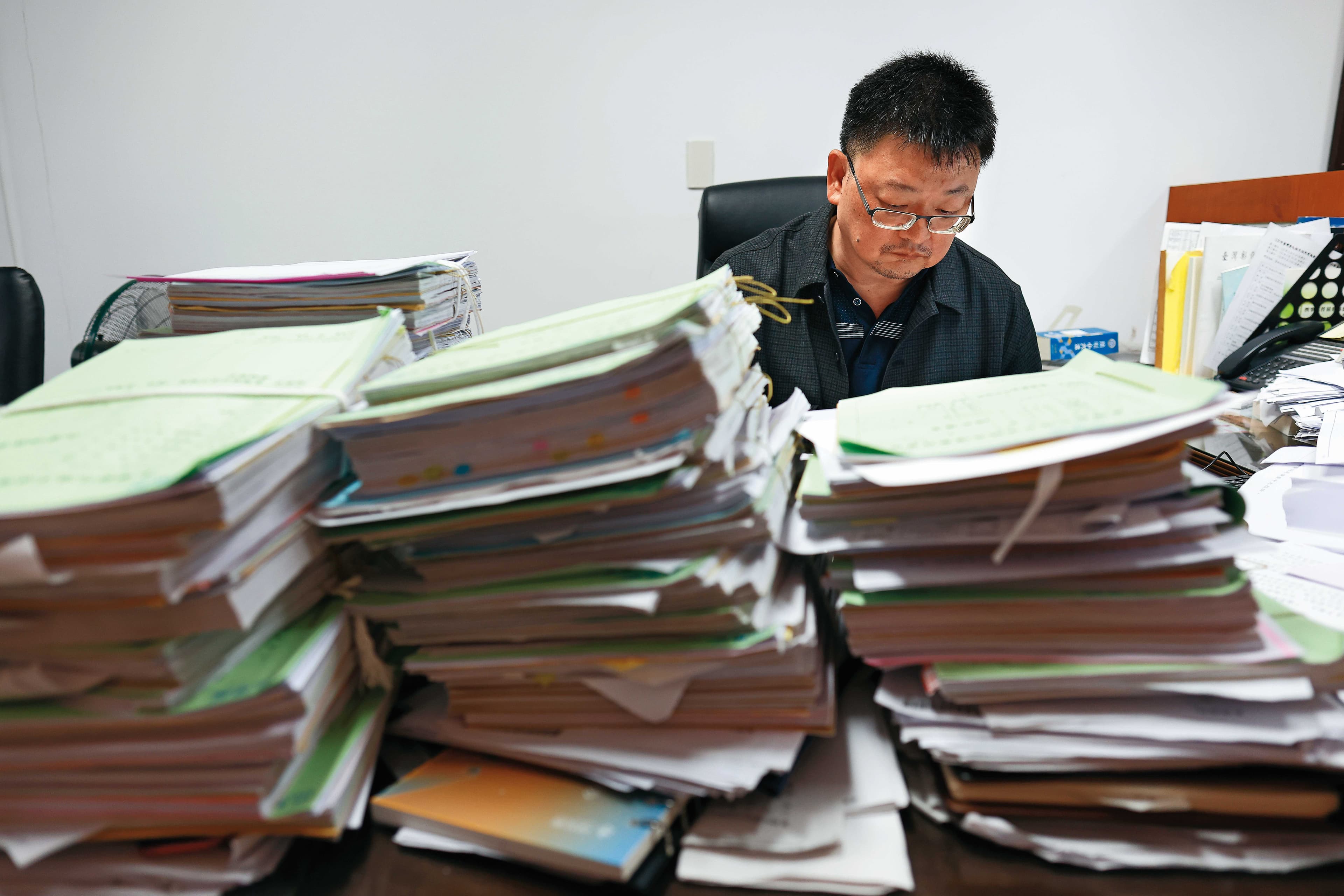 鮑慧忠的桌上堆滿卷宗，他說，近年法院快要被詐騙案件淹沒。