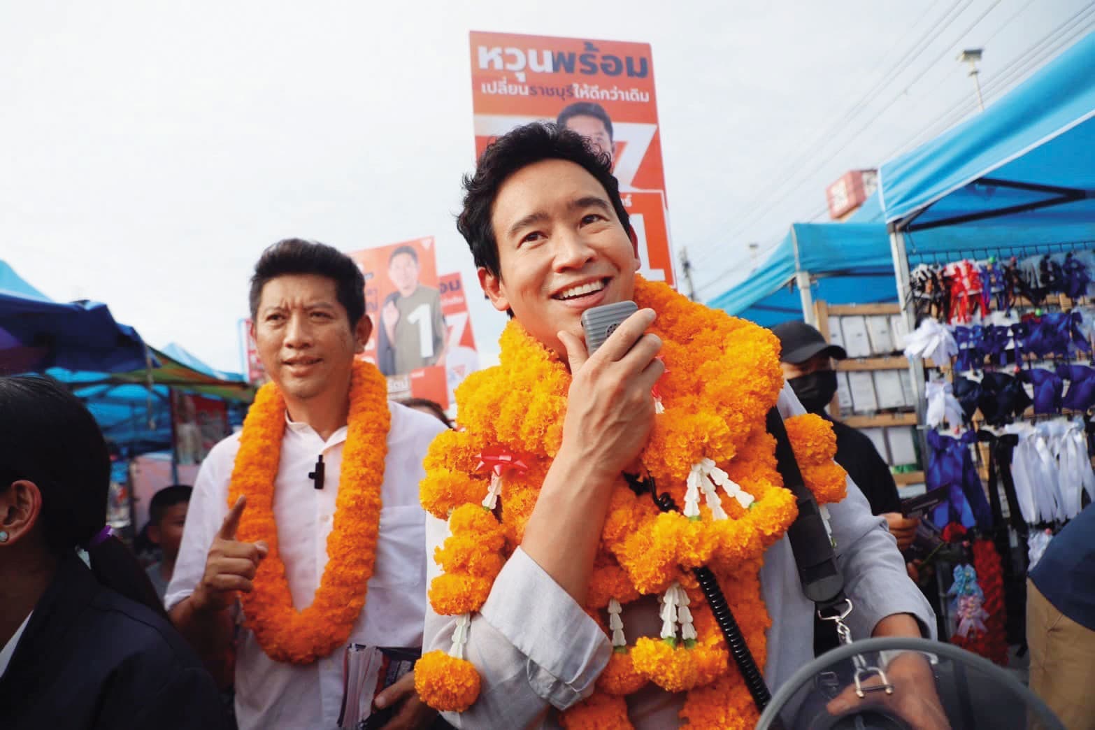2月8日是泰國大選日。皮塔（右）是人民黨的最佳助選員，身上掛滿民眾給他的萬壽菊花環，掛得越多，代表人氣越高。（翻攝自皮塔臉書）