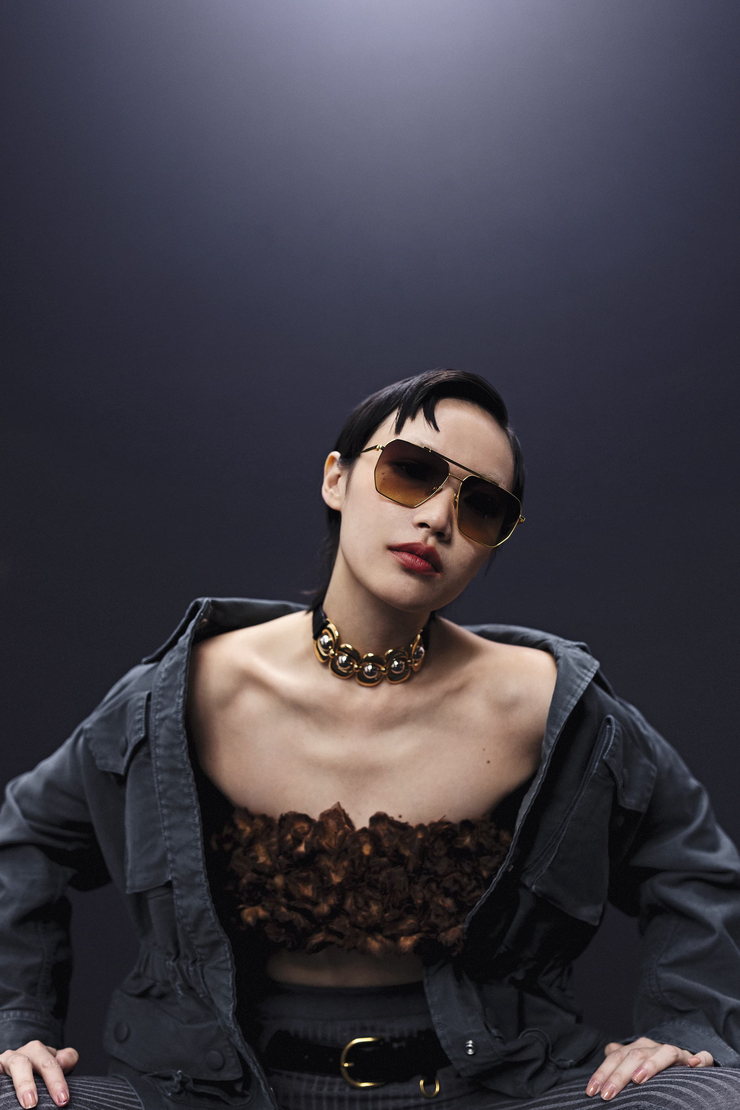 絲質花卉上衣 NT$275,000 by PRADA／鐵灰色棉質收腰外套 NT$150,000 by PRADA／灰色棉質褲襪（附腰帶） NT$54,000 by PRADA／飛行員太陽眼鏡 NT$549 by H&M／皮革手環（作為項鍊） NT$33,500 by miu miu