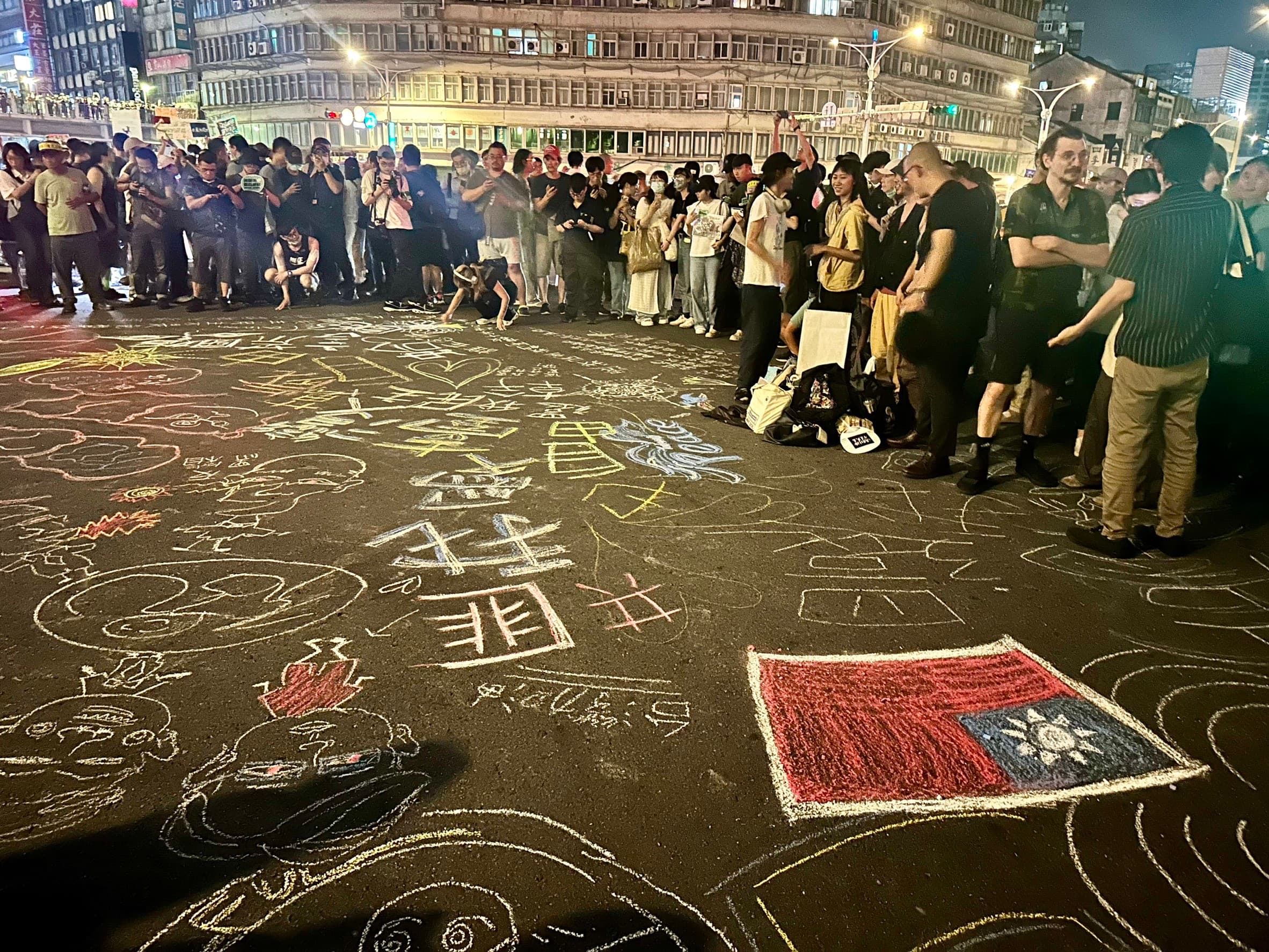 民眾不只舉標語表達訴求，還在柏油路上作畫。