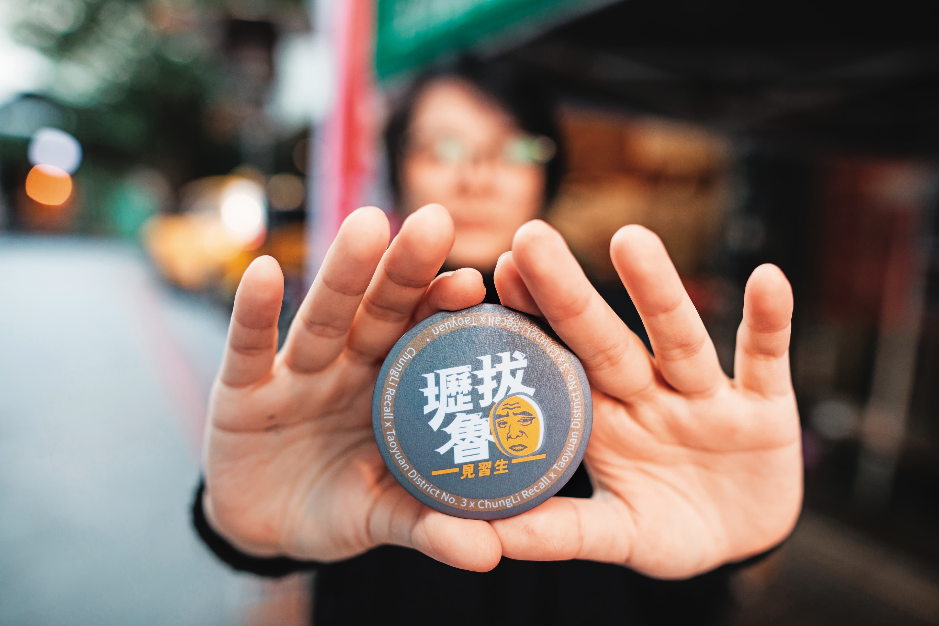 Dora秀出自己設計的罷免小徽章。