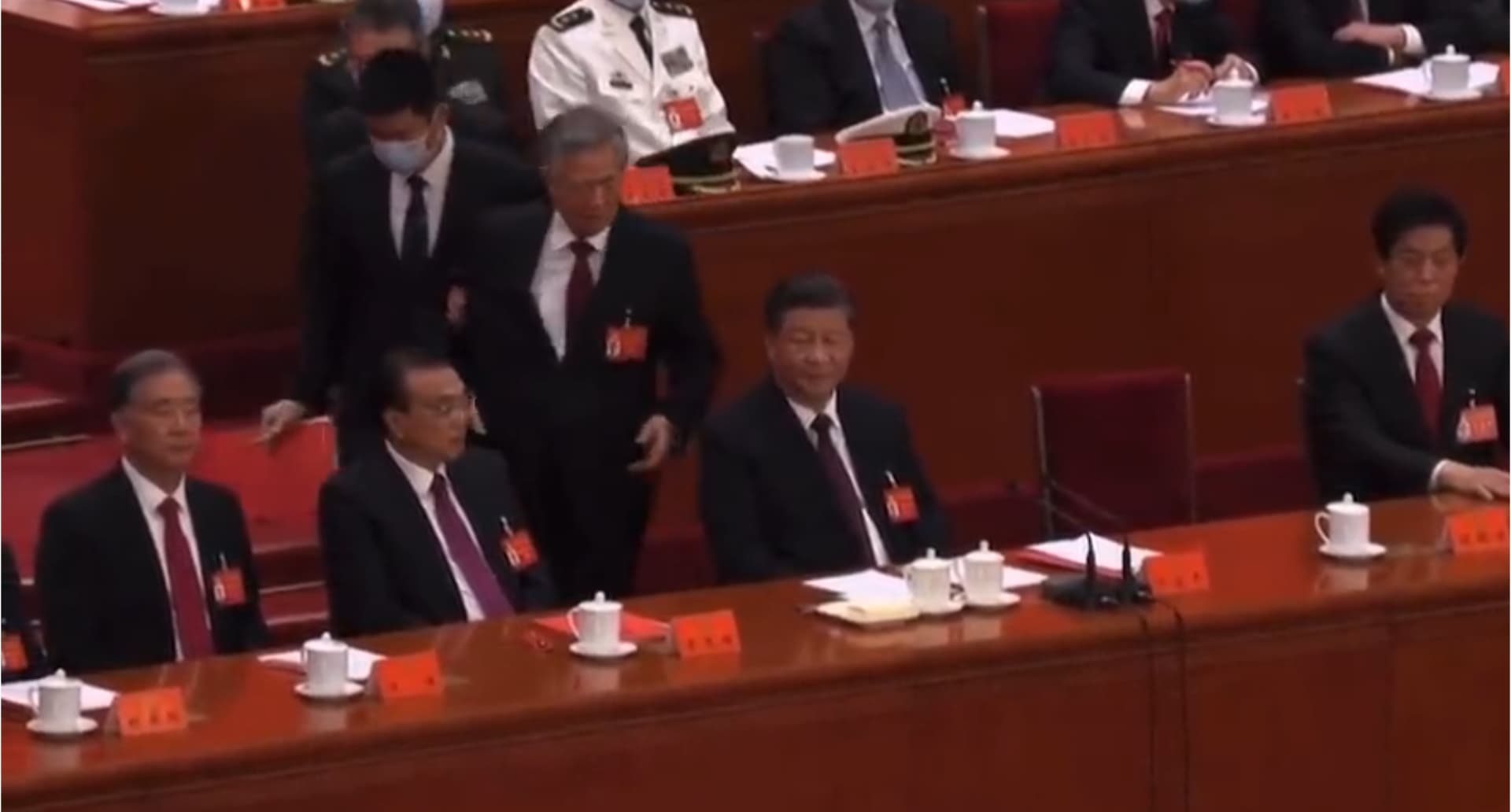 2022年中共二十大上。胡錦濤「被攙扶離場」，還曾回頭看了一眼習近平，引發各種解讀。（翻攝畫面）