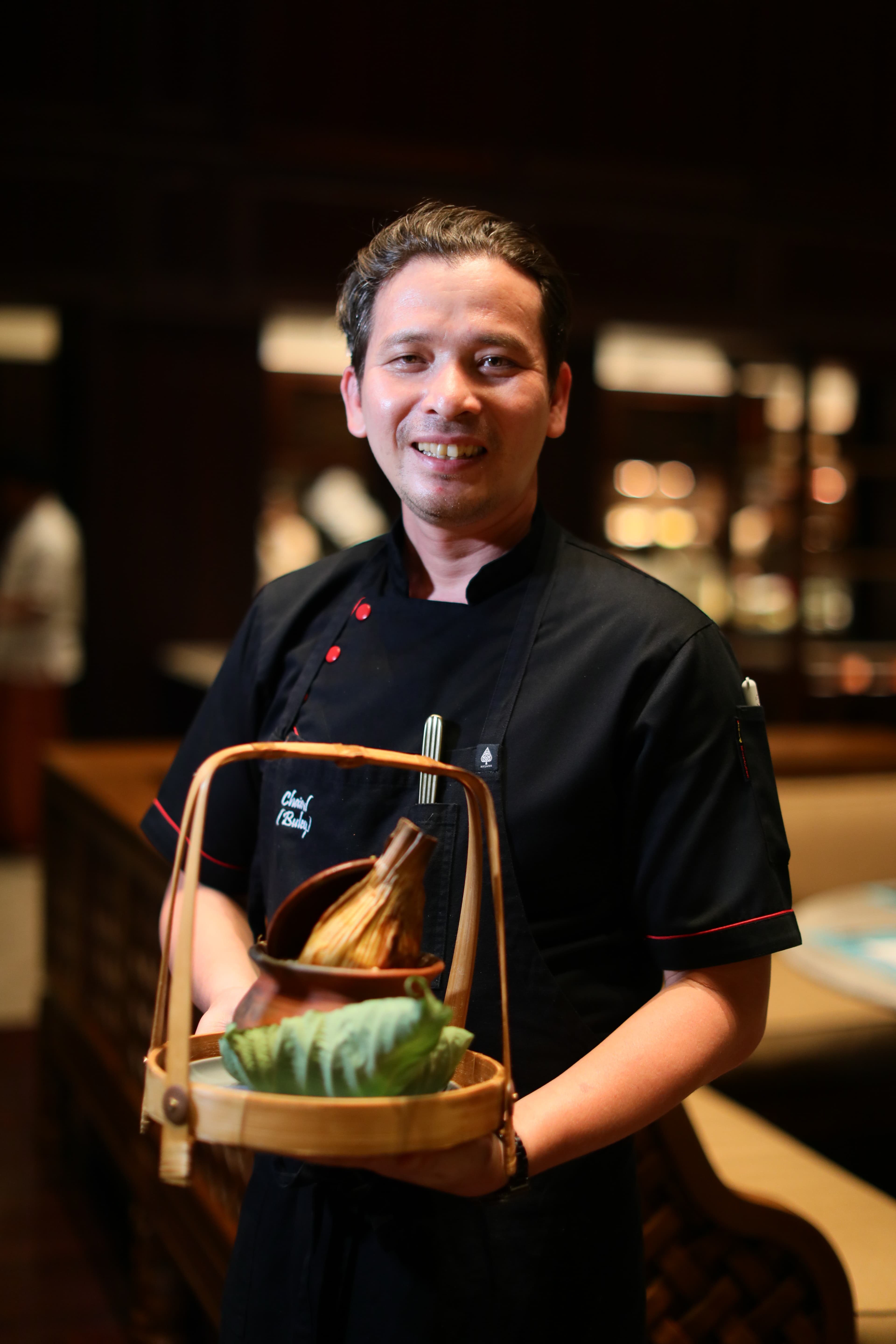 主廚端出剛完成的峇里島式香料燉雞。