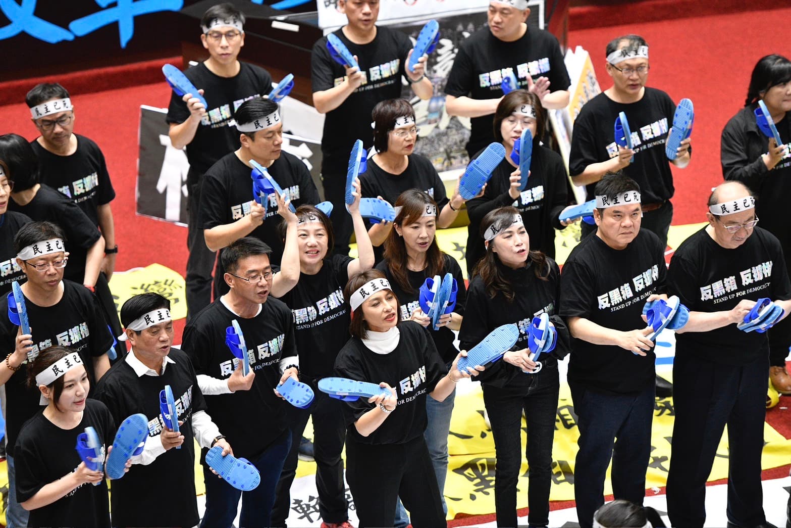 民進黨立委下午改走較溫和的方式抗爭，紛紛拿出「藍白拖」揶揄藍白兩黨。