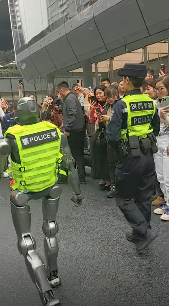 「機器人警察」穿警用背心上街，引發民眾圍觀。（翻攝抖音）