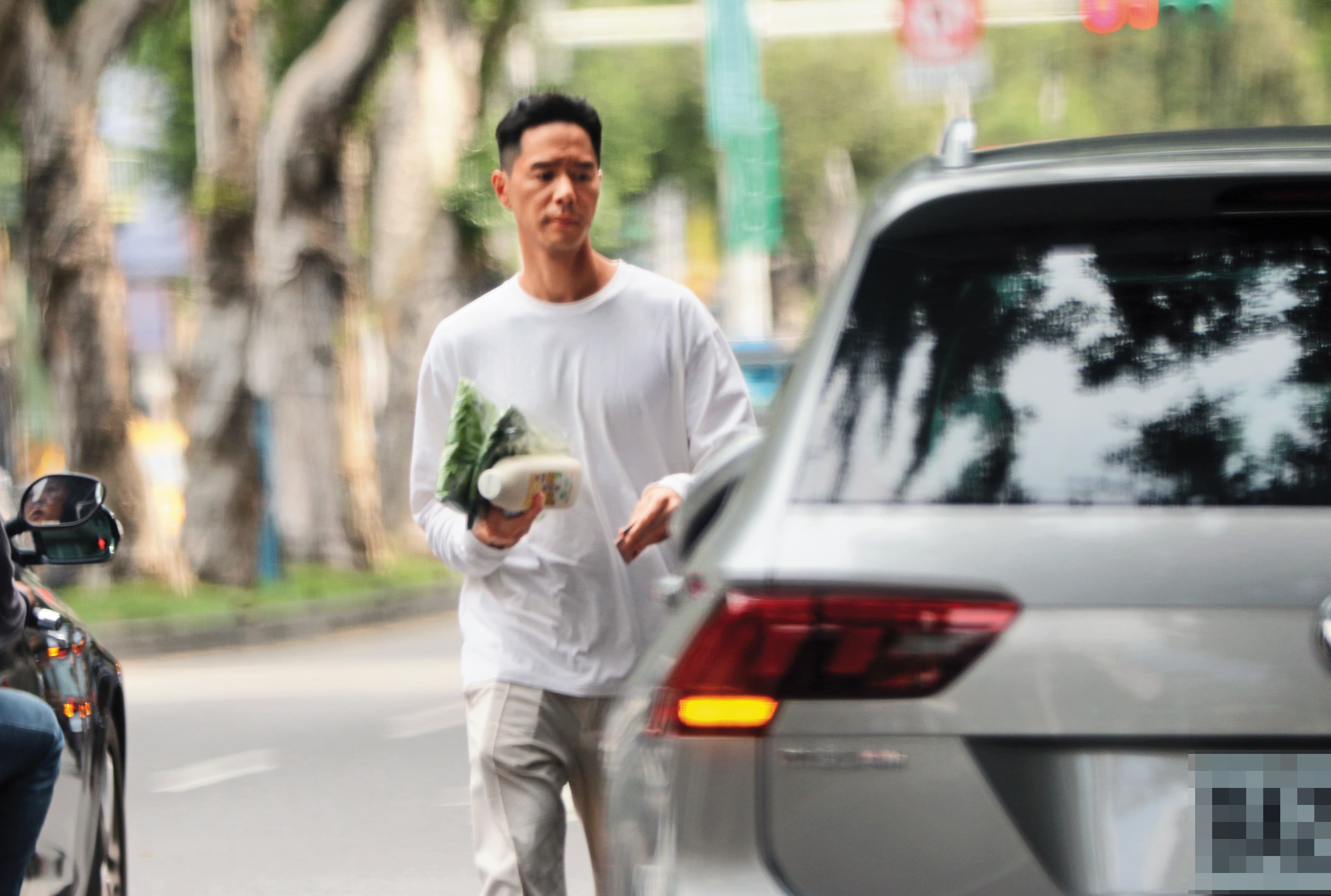 丁春誠一手抓了兩包菜和一瓶豆漿後，就驅車離開回到台北關渡某個社區。