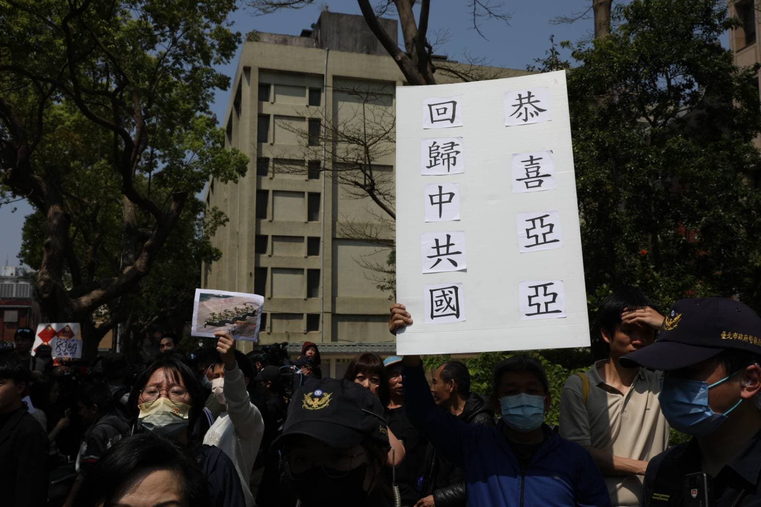 群眾舉牌「恭喜亞亞回歸中共國」。