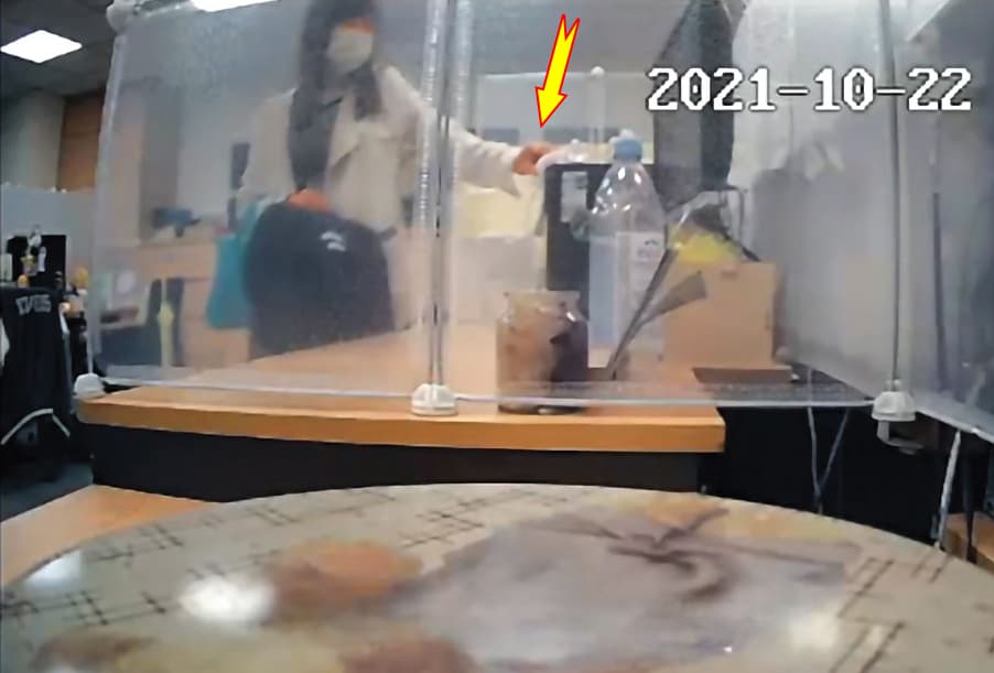 張靖玲將手隔著衛生紙，私自將古彩彥的電腦關機，遭針孔攝影機錄下。（翻攝判決書）
