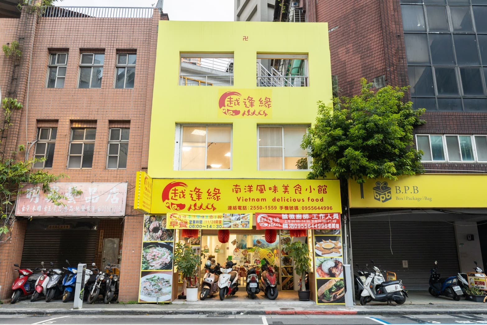 「越逢緣南洋風味美食小館」的亮黃色系外觀，在色彩低調的街道上十分搶眼。