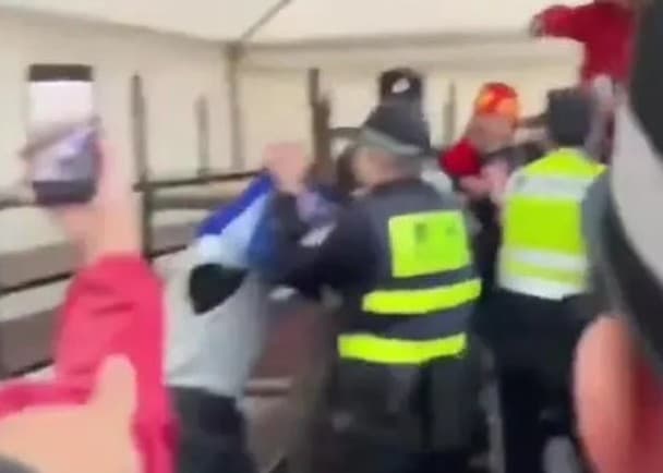 中國警方強行把男子身上的球衣脫下。（翻攝自X＠清丝老师谈治国理政）