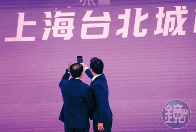 雙城論壇去年8月30日在上海舉辦，蔣萬安（右）在台上拿起手機拍照，留下紀念。（本刊資料照）