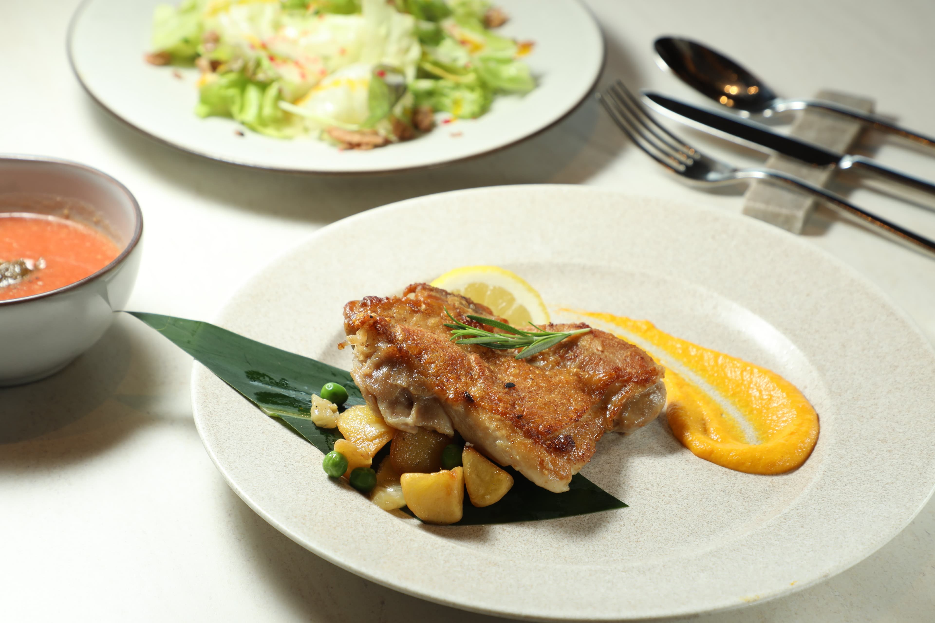 PANORAMA DINING的「炭烤香草山原雞」使用山原大自然孕育的香草雞，烤至外皮金黃酥脆。（3,000日圓／份，約NT$594）