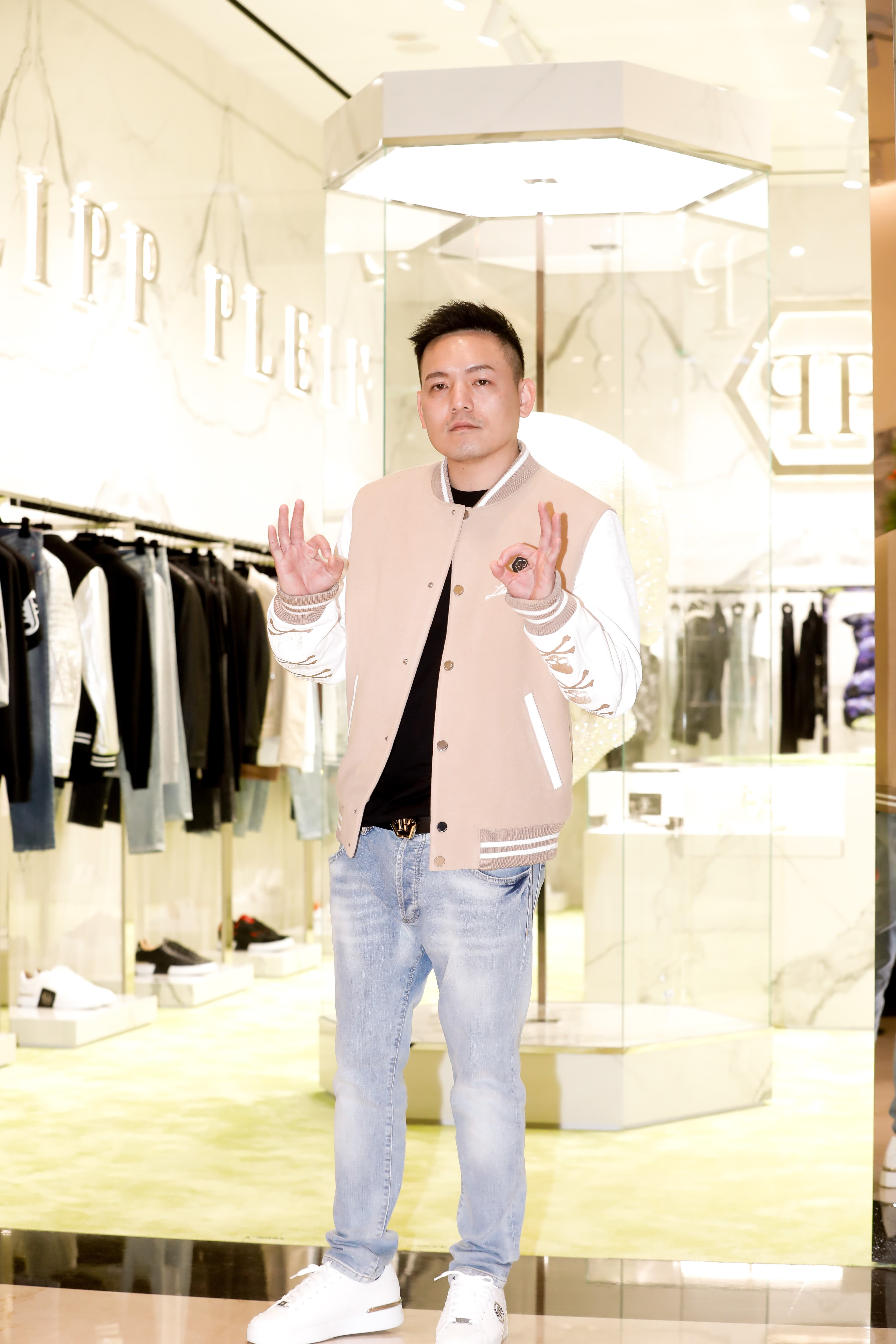 春風身著PHILIPP PLEIN棒球外套（NT$136,750）、丹寧牛仔褲（NT$34,310），搭配蟒蛇壓紋球鞋（NT$59,580）。