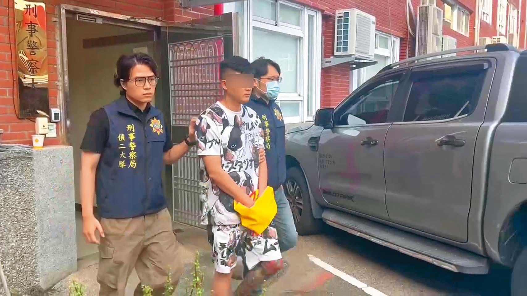 三環幫吳姓幹部（中）設立融資公司進行詐騙，還要求無擔保品的民眾辦假購車貸款專案。（翻攝畫面）
