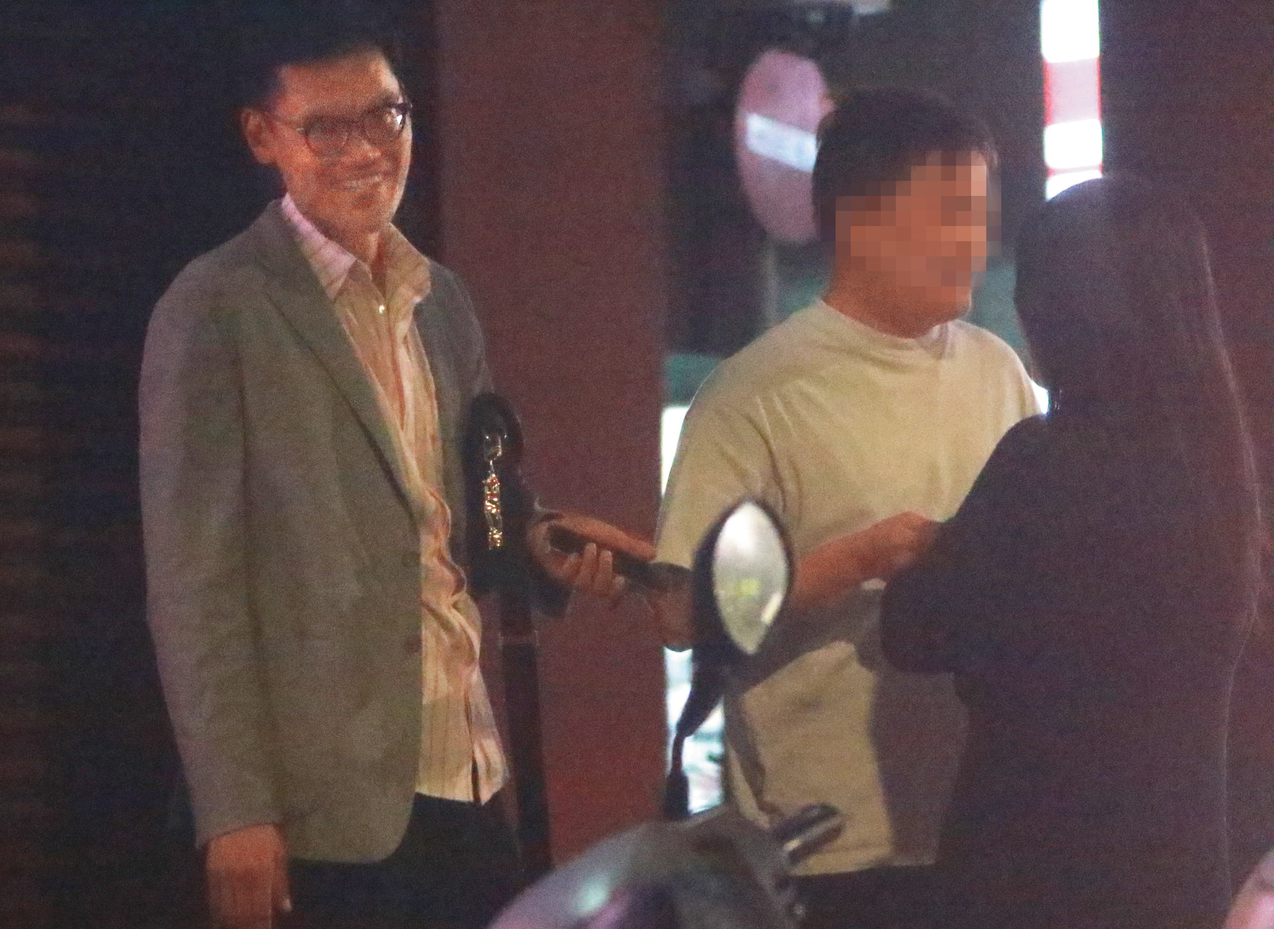 4/30，00：46，除了吳女的家，這天張軒銘（左）在自家社區前與一對男女談話，所在位置是台北文山區的別墅區大門。