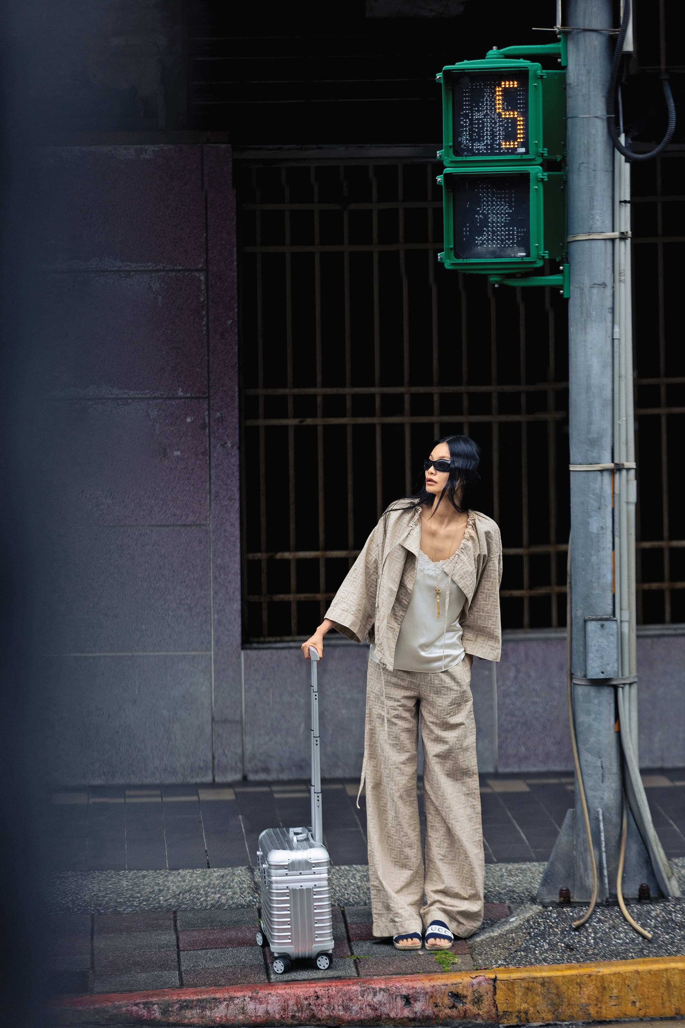 夏季系列設計外套 NT$61,200 by FENDI；Triomphe刺繡絲質背心 價格店洽 by CELINE；夏季系列設計長褲 NT$44,800 by FENDI；編織涼鞋 NT$26,900 by GUCCI；黑色圓墨鏡 NT$18,500 by DIOR；復古金長項鍊 價格店洽 by Chloe；Original系列機長箱 NT$51,700 by RIMOWA。