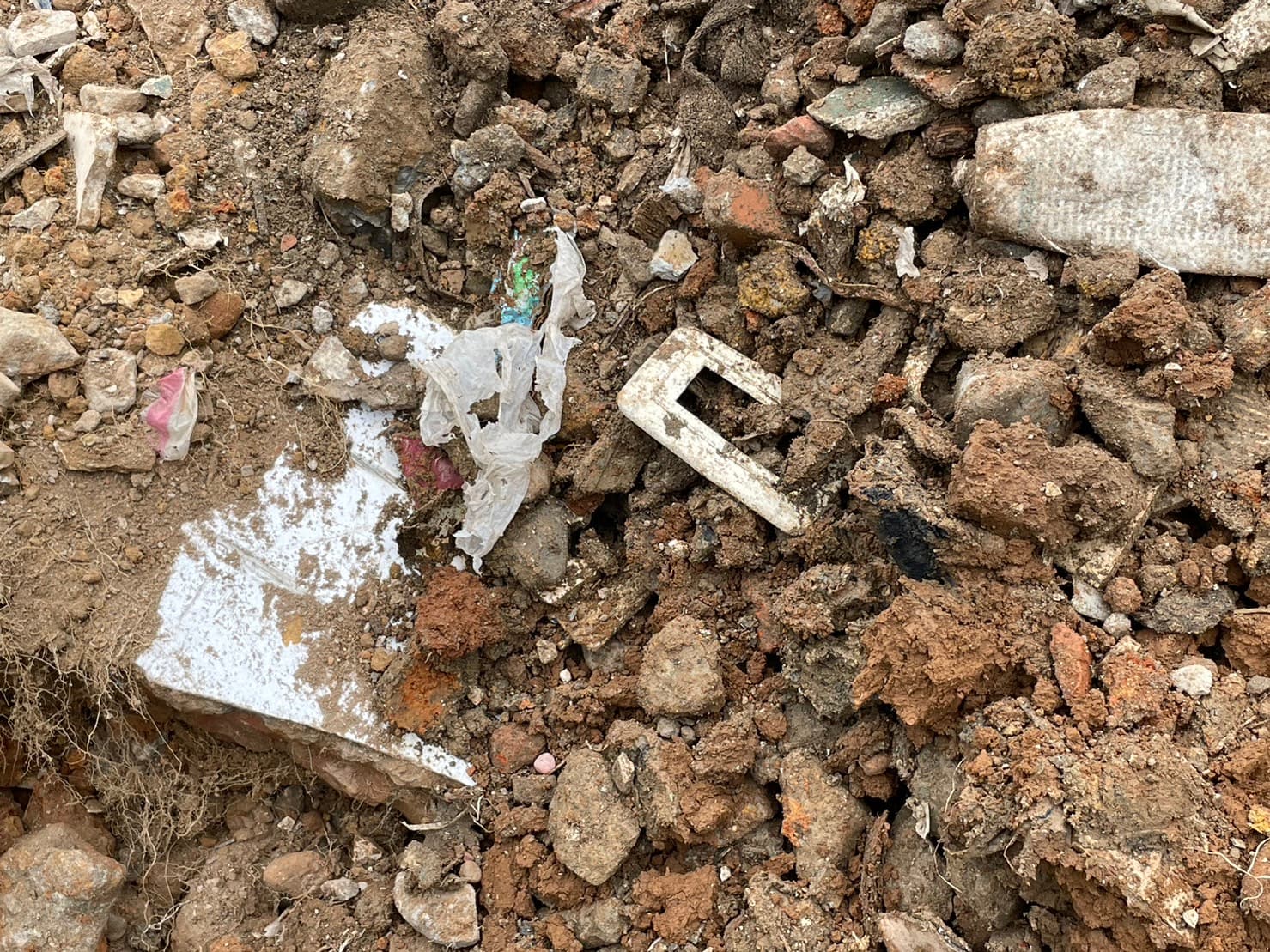 農地埋有垃圾、廢塑膠、廢鋼筋、鐵條、木材等大量營建廢棄物。（警方提供）