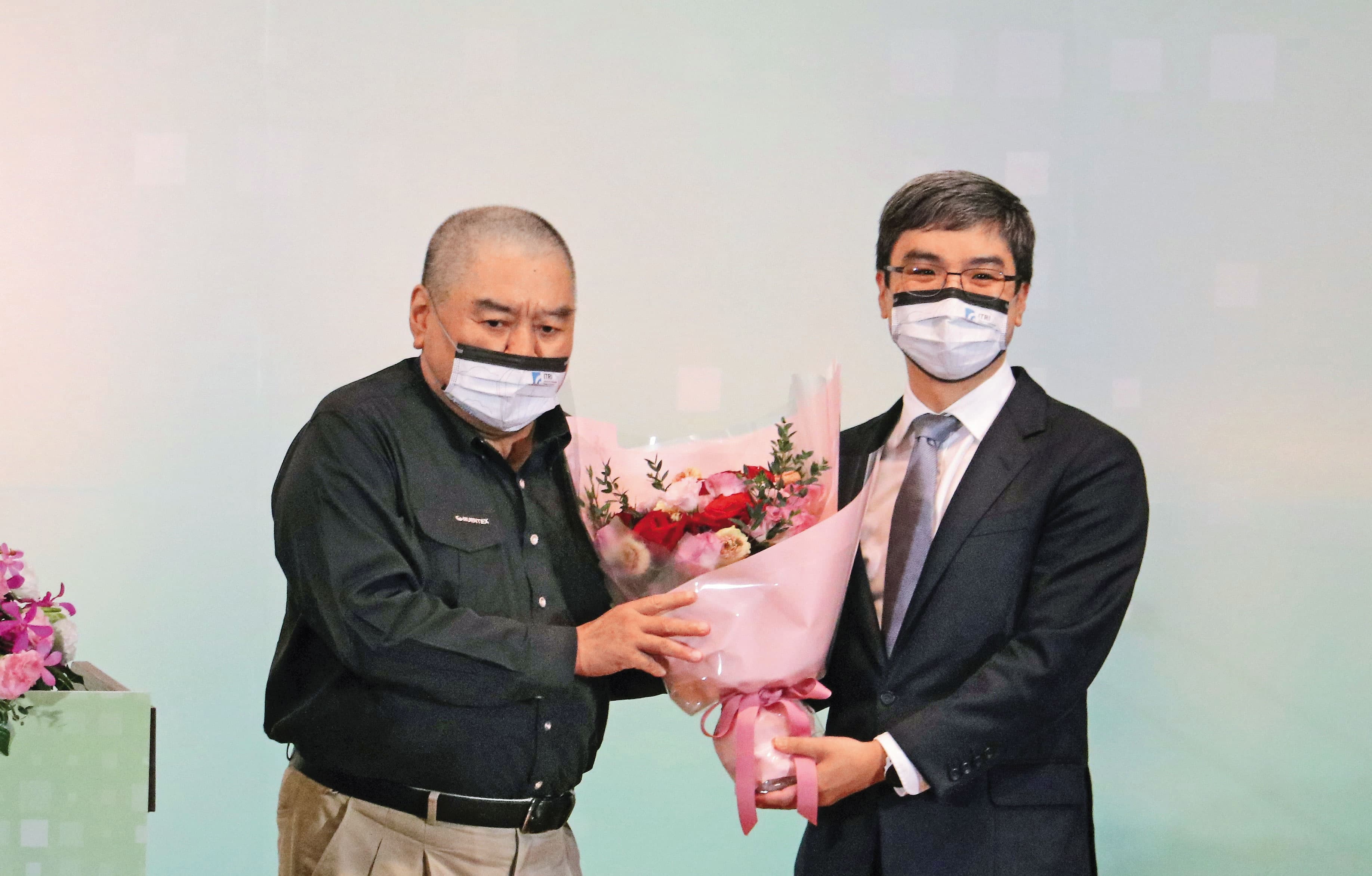 尹衍樑（左）獲選為工研院院士，由任職南山人壽董事長的兒子尹崇堯（右）獻花致意。（唐獎教育基金會提供）