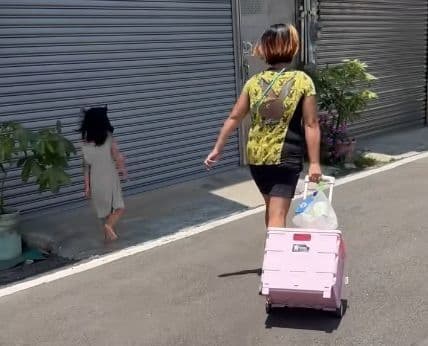 小孩子受不了疼痛，試圖躲到陰影處，卻被媽媽一把拉回太陽底下繼續踩在滾燙的柏油路上走。（翻攝自臉書社團「新竹大小事」）