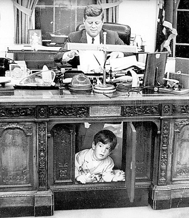 1963年2歲的小約翰甘乃迪在父親辦公桌下玩耍，堪稱白宮經典畫面。（翻攝X@HistoricHub）