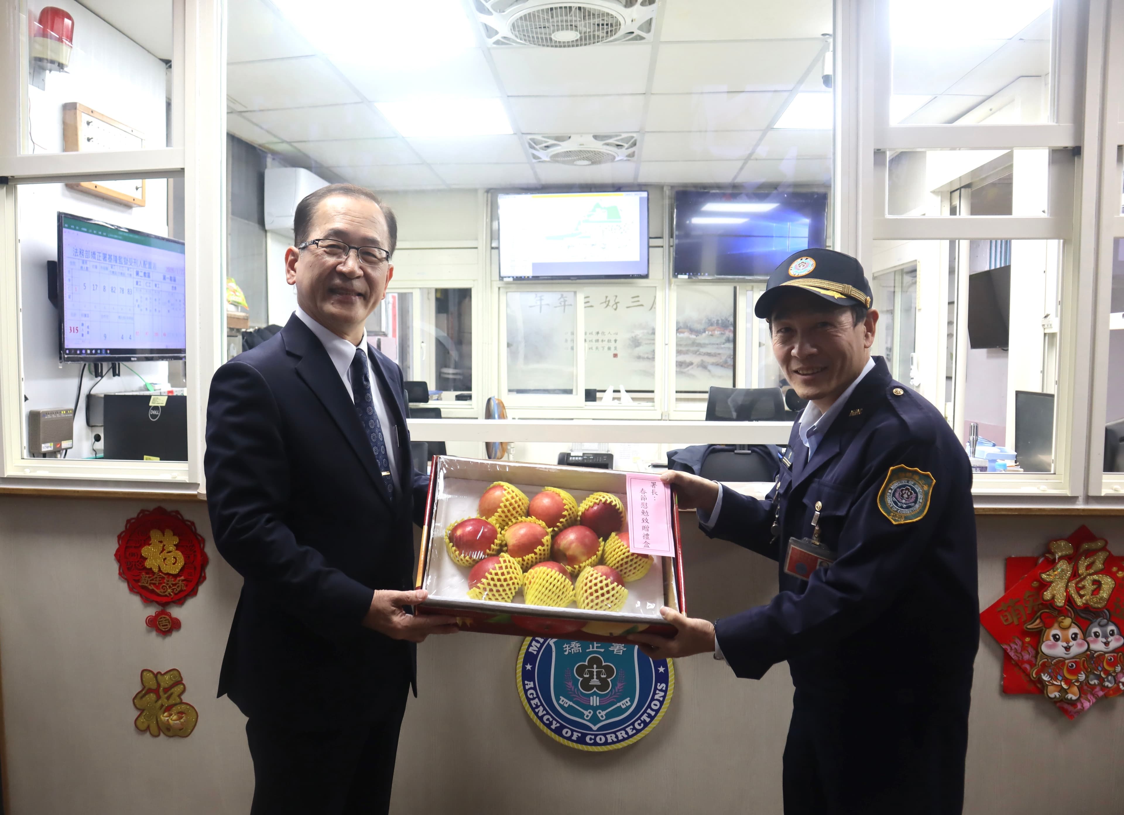 矯正署長林憲銘（左）送上蘋果禮盒，象徵平平安安。（矯正署提供）