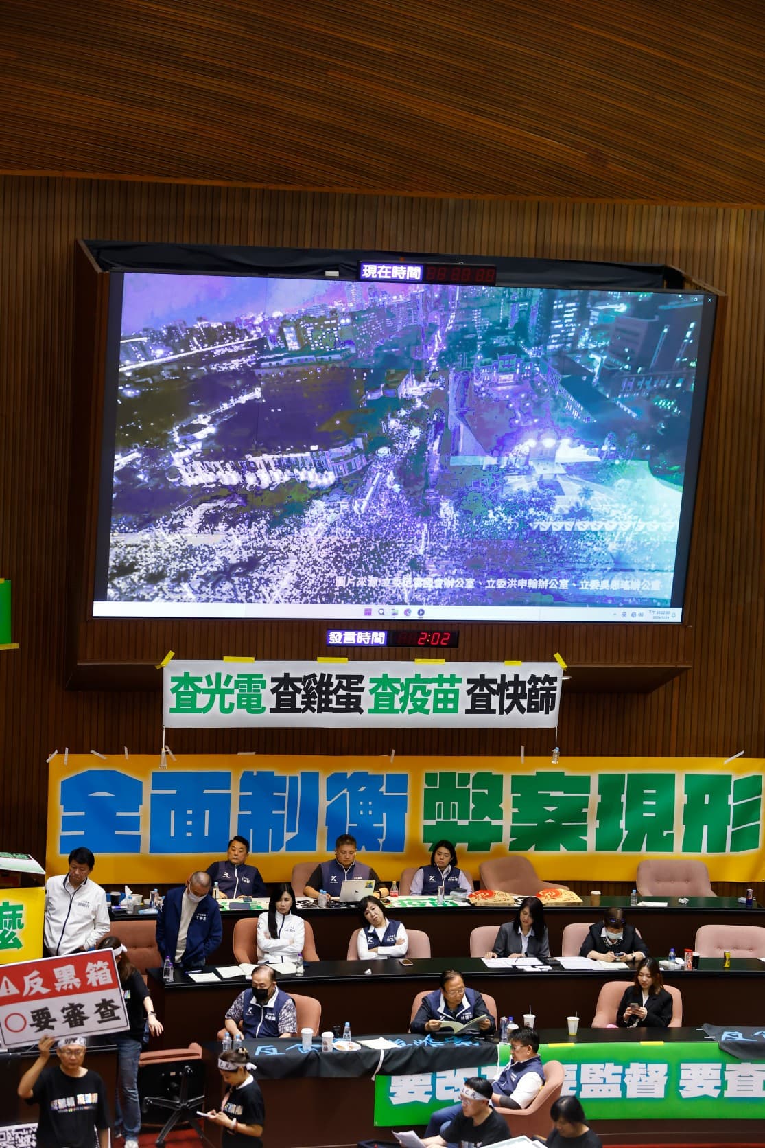 議場螢幕放出場外人潮，對比場內藍委的無視。