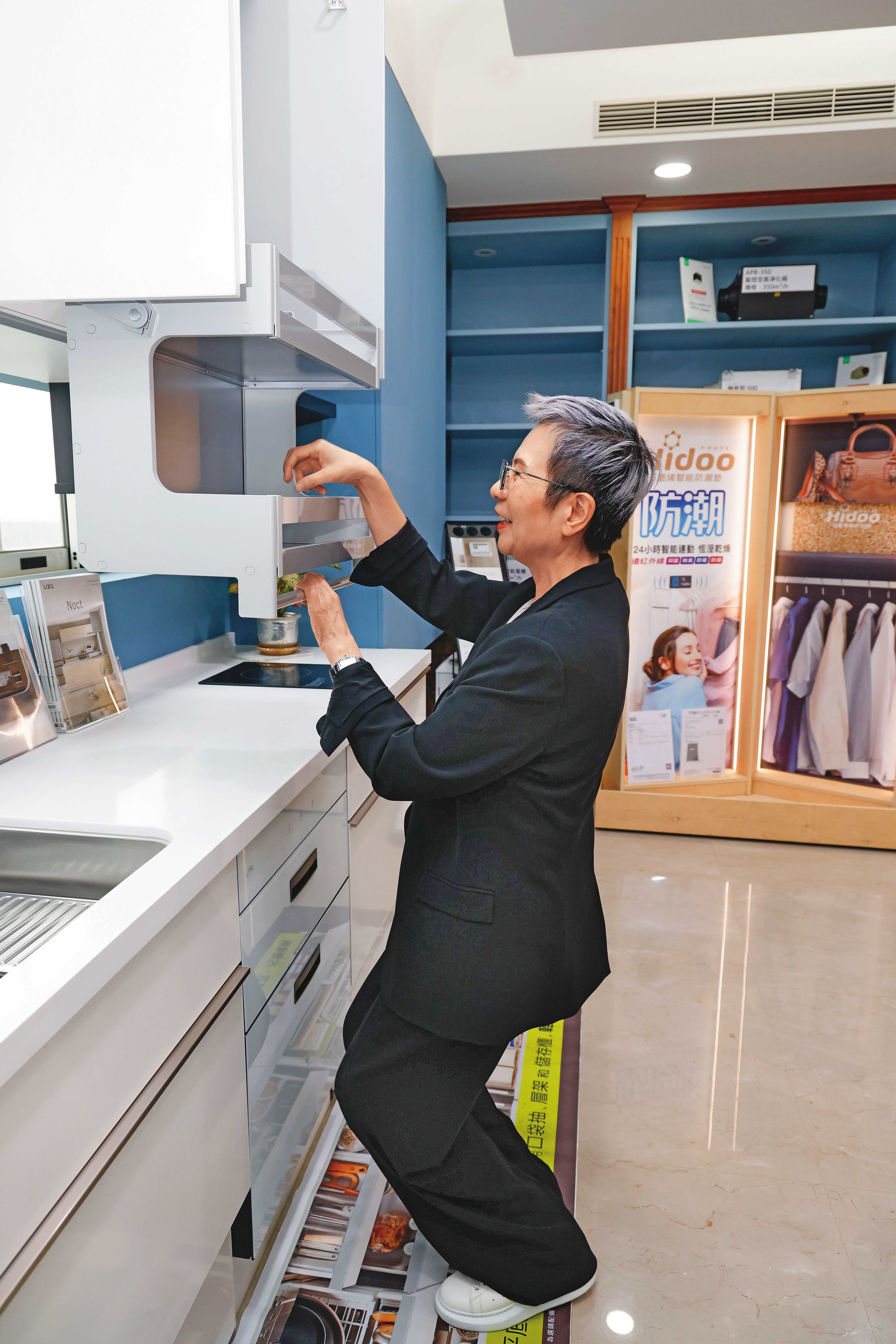 曾婷婷代理日本LIXIL樂齡廚具，她示範即使坐在輪椅上，也可輕易下拉櫃子。