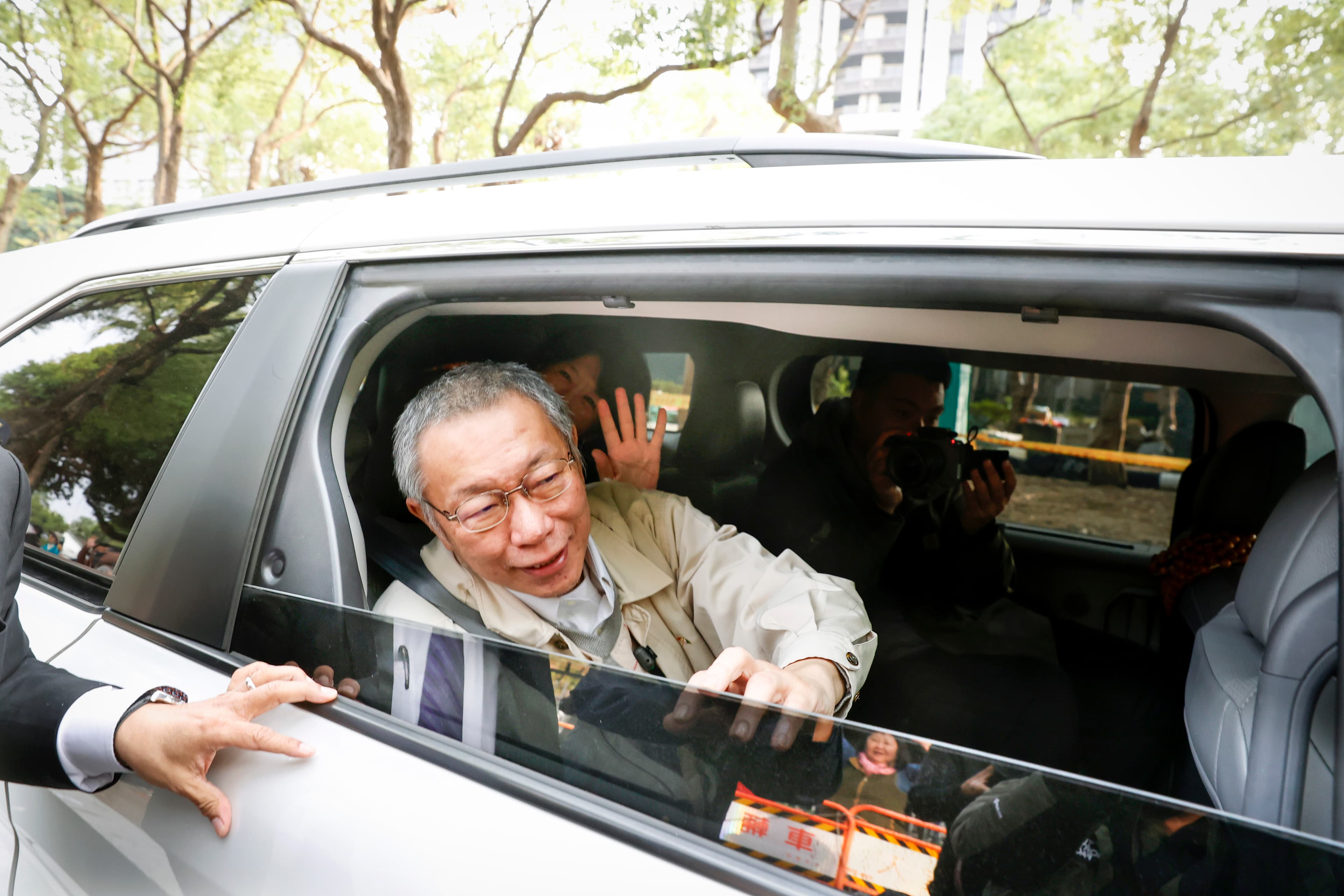 柯文哲座車放慢速度，搖下車窗讓柯能跟小草揮手致意。