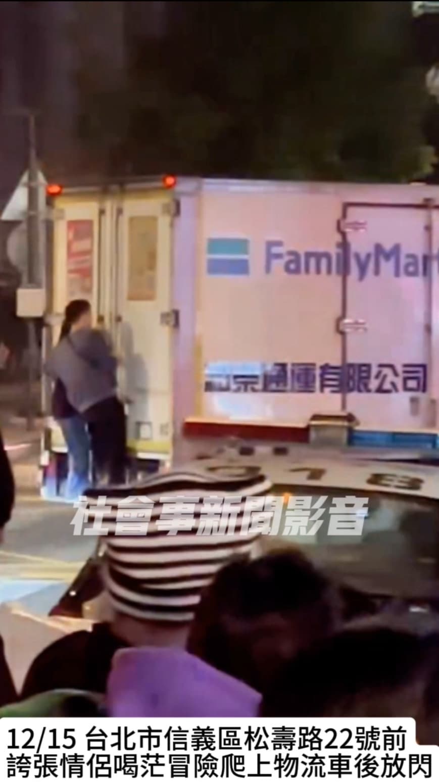 情侶站在貨車後方車斗橫桿上，不時親吻放閃。（翻攝自社會事新聞影音）