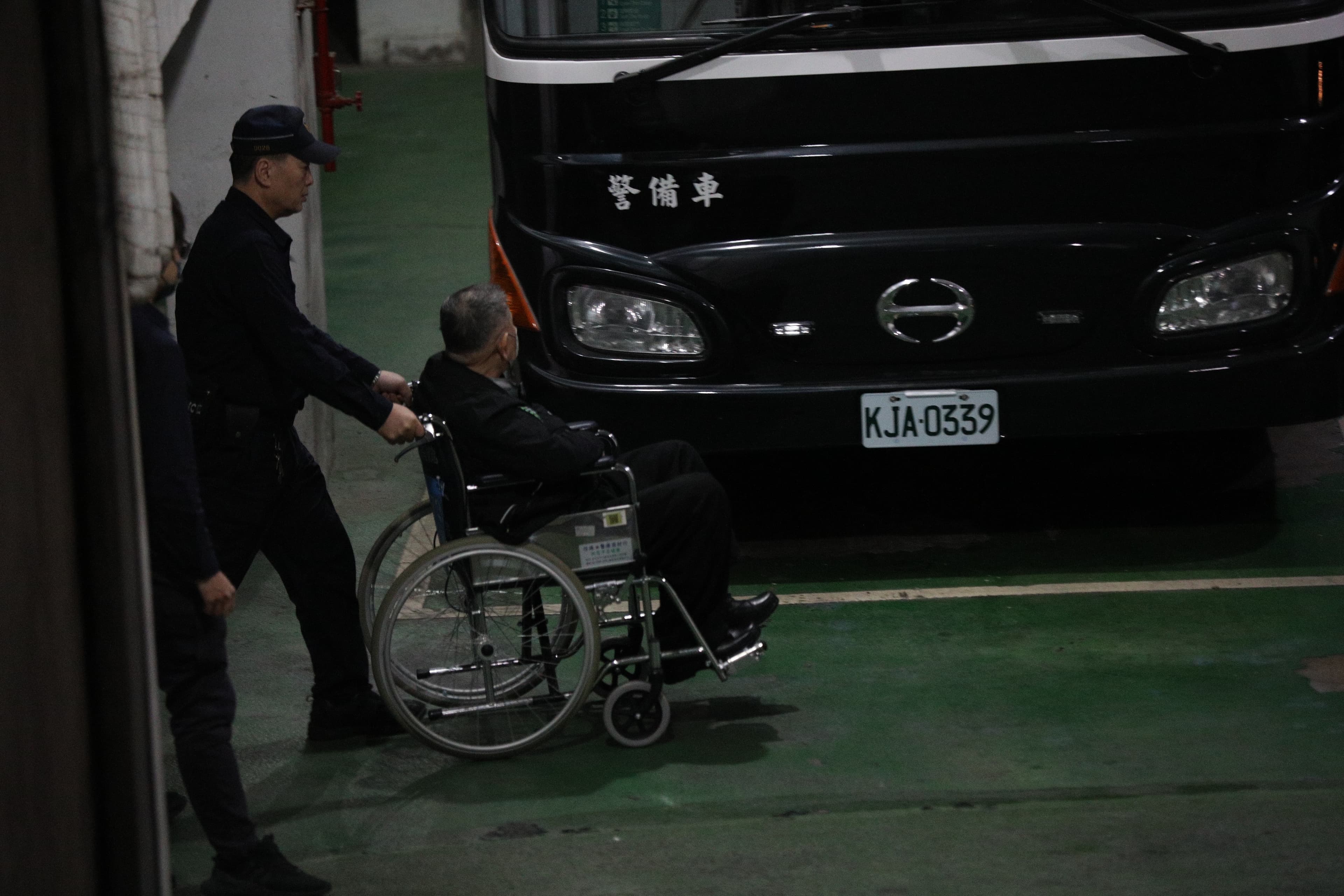 2日晚間沈慶京（右）遭裁定羈押禁見後，坐在輪椅上被推向警備車，前往台北看守所。