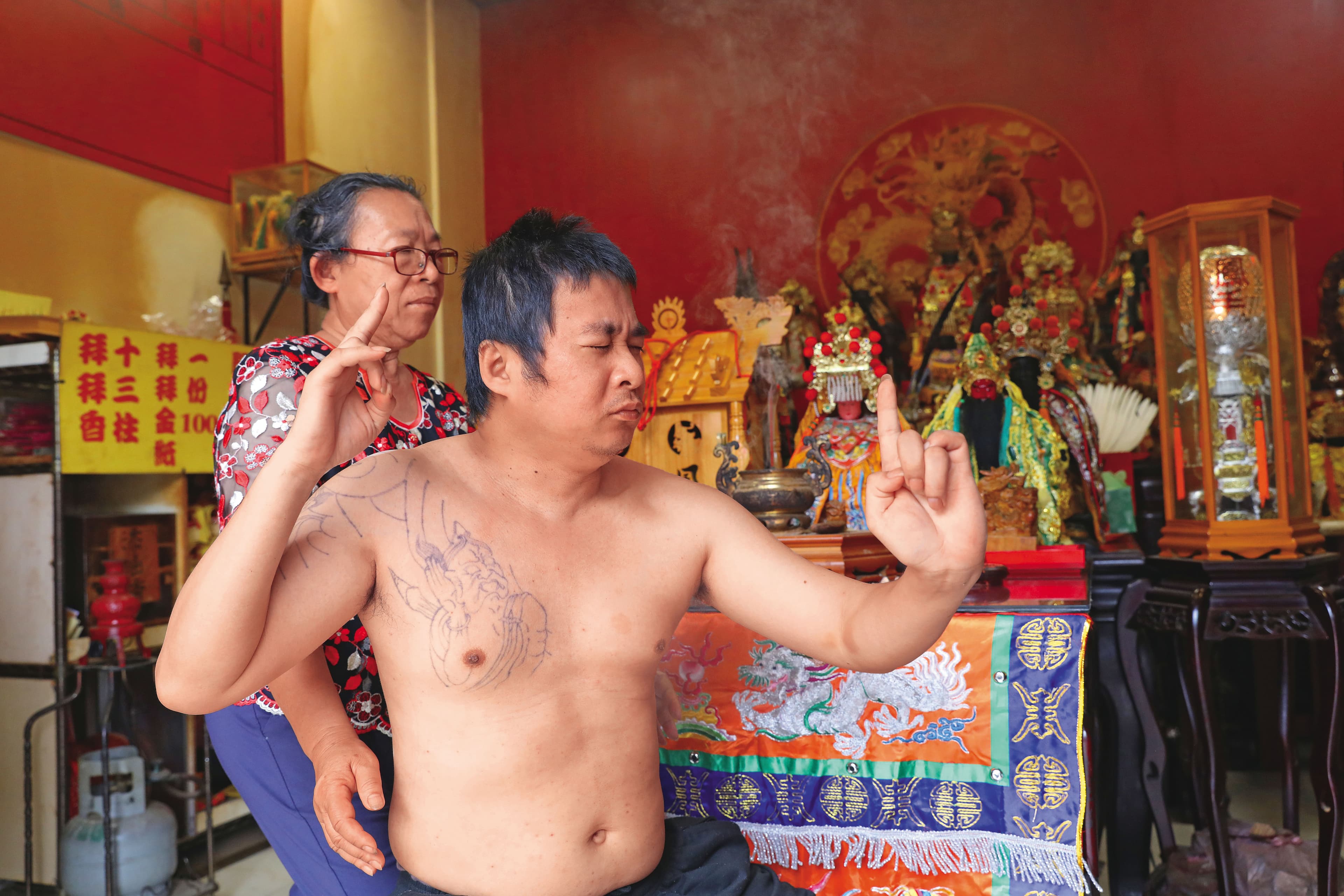 呂金葉（後）與兒子王皇朝（前）分別是媽祖與玄天上帝的乩童，每週固定在自家宮廟「辦事」。
