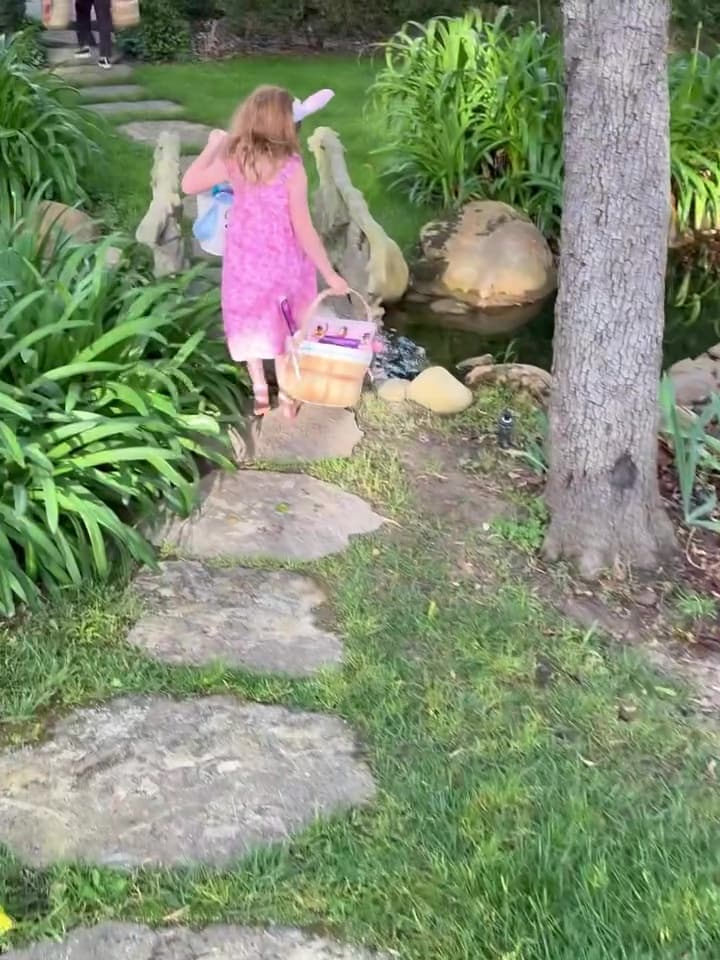 莉莉貝戴著兔耳朵，提籃子走過小橋流水。（翻攝meghan IG）