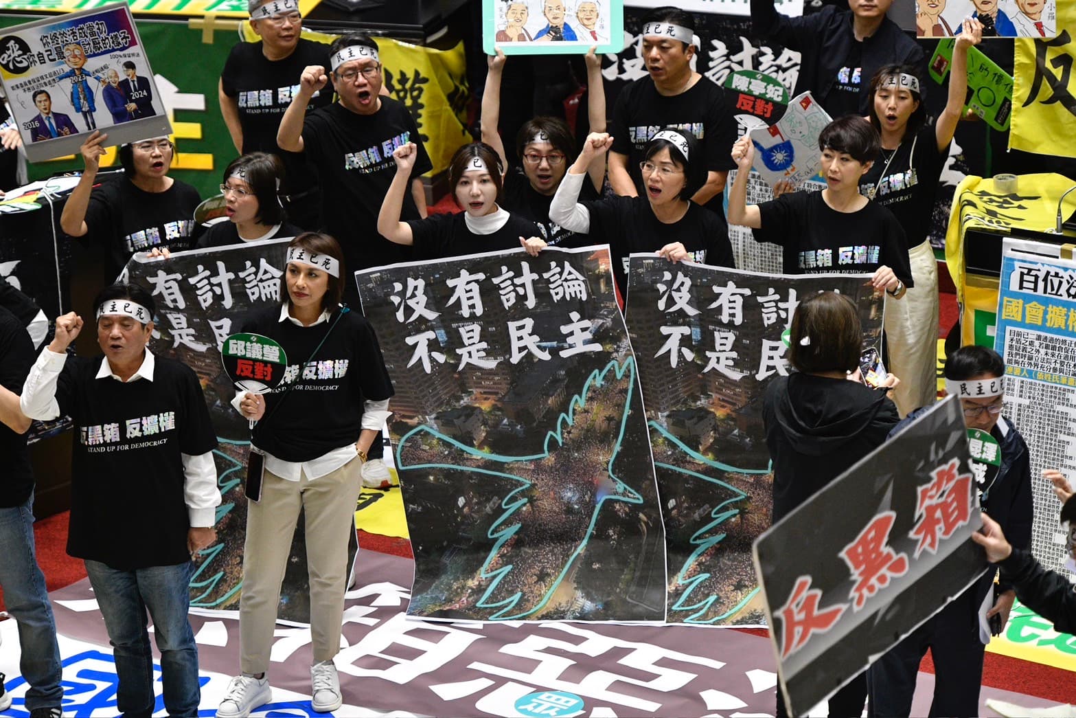 綠營隨後不甘示弱集結叫陣，到議場中央齊聲高呼「沒有討論、不是民主、反黑箱、反擴權」。