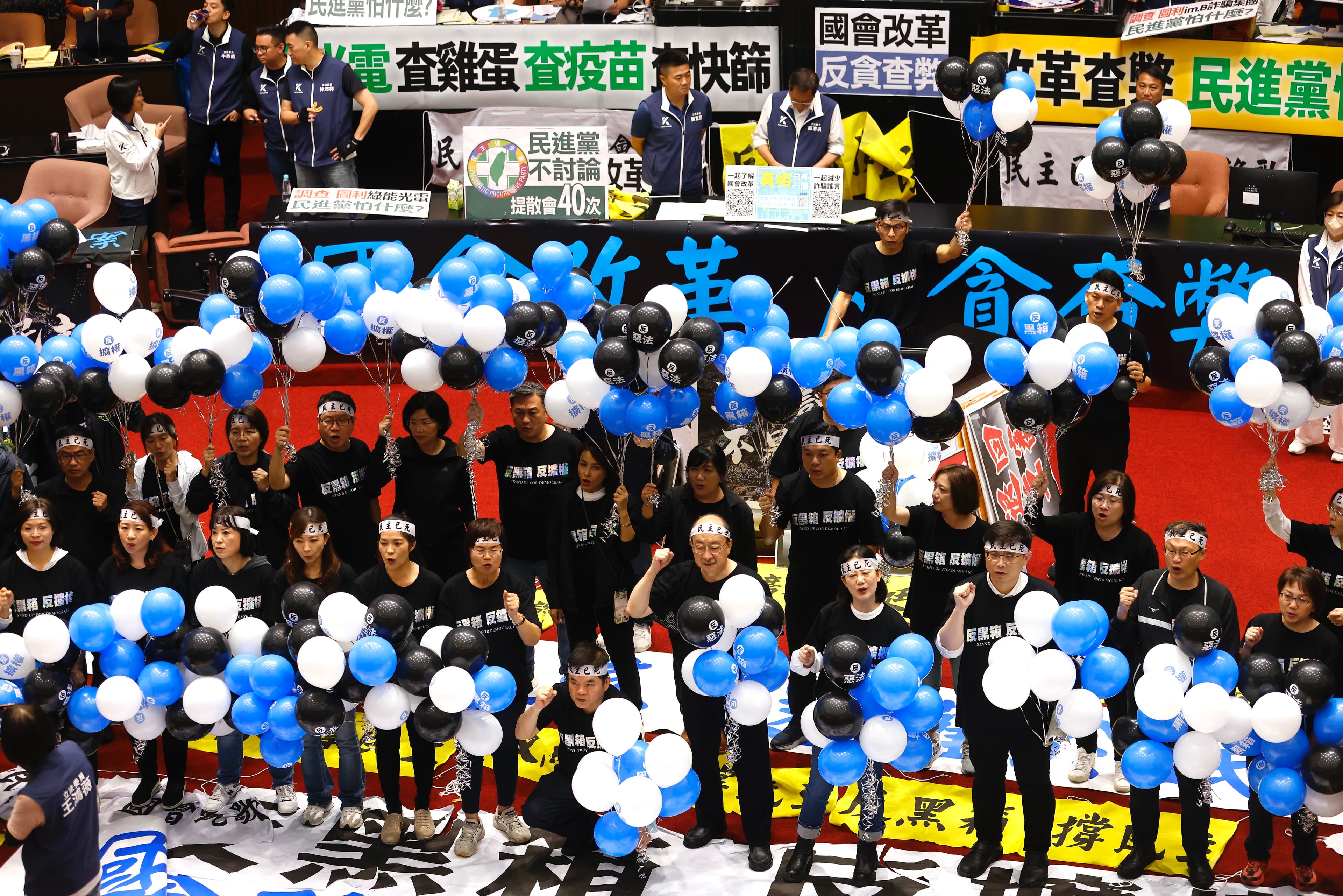 民進黨立委人手一串「藍白黑」氣球，象徵藍白黑箱的幽靈盤據在立法院上空。