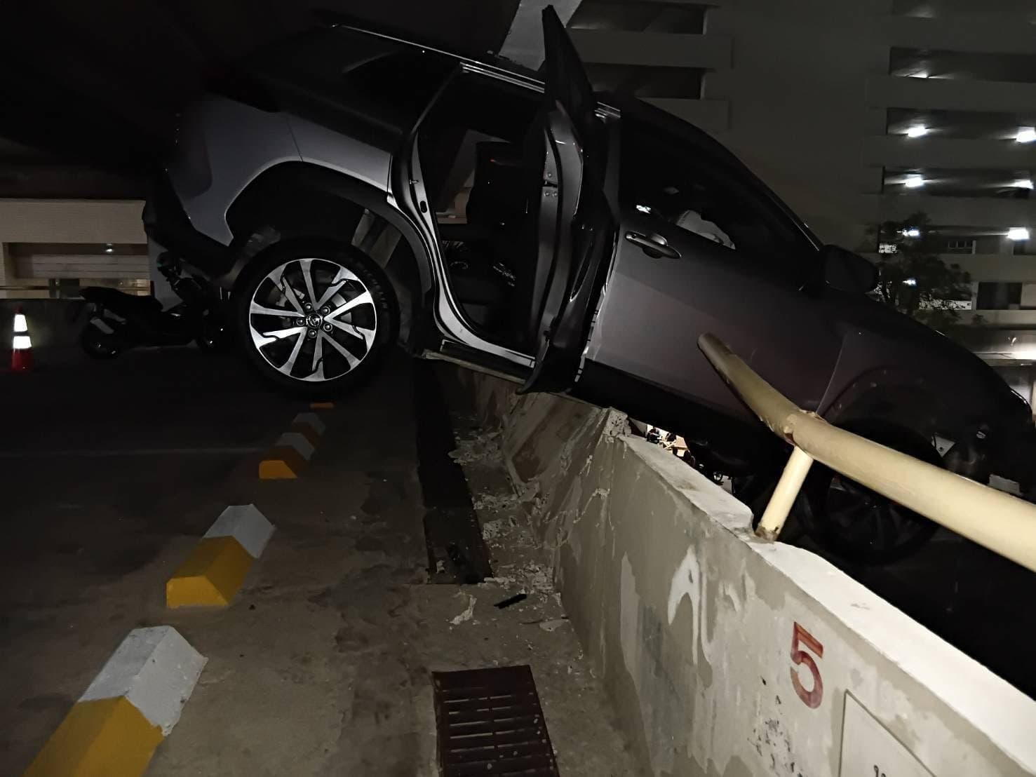1輛休旅車失控衝破外牆，車頭懸空掛在樓層邊緣，整輛車搖搖欲墜。（翻攝自Sittipon Benz FB）