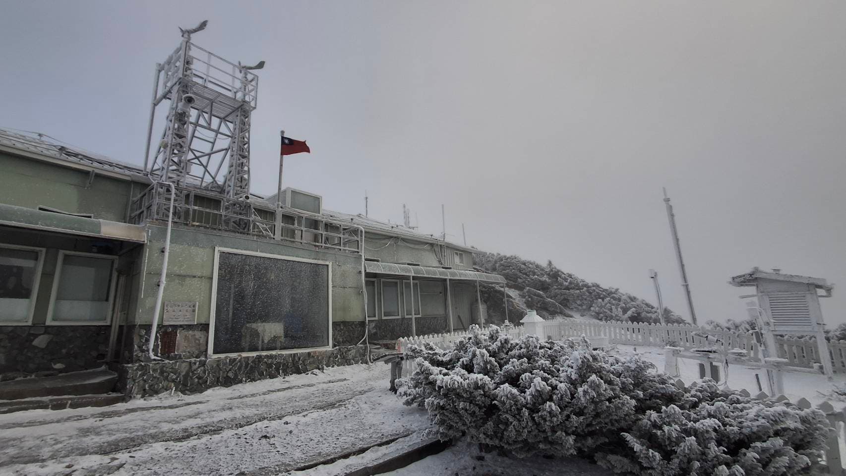 玉山氣象站今6時許觀測到降雪，8時仍在降雪中，可以看到氣象站壟罩在一片雪白中。（翻攝自臉書@報天氣 - 中央氣象署）