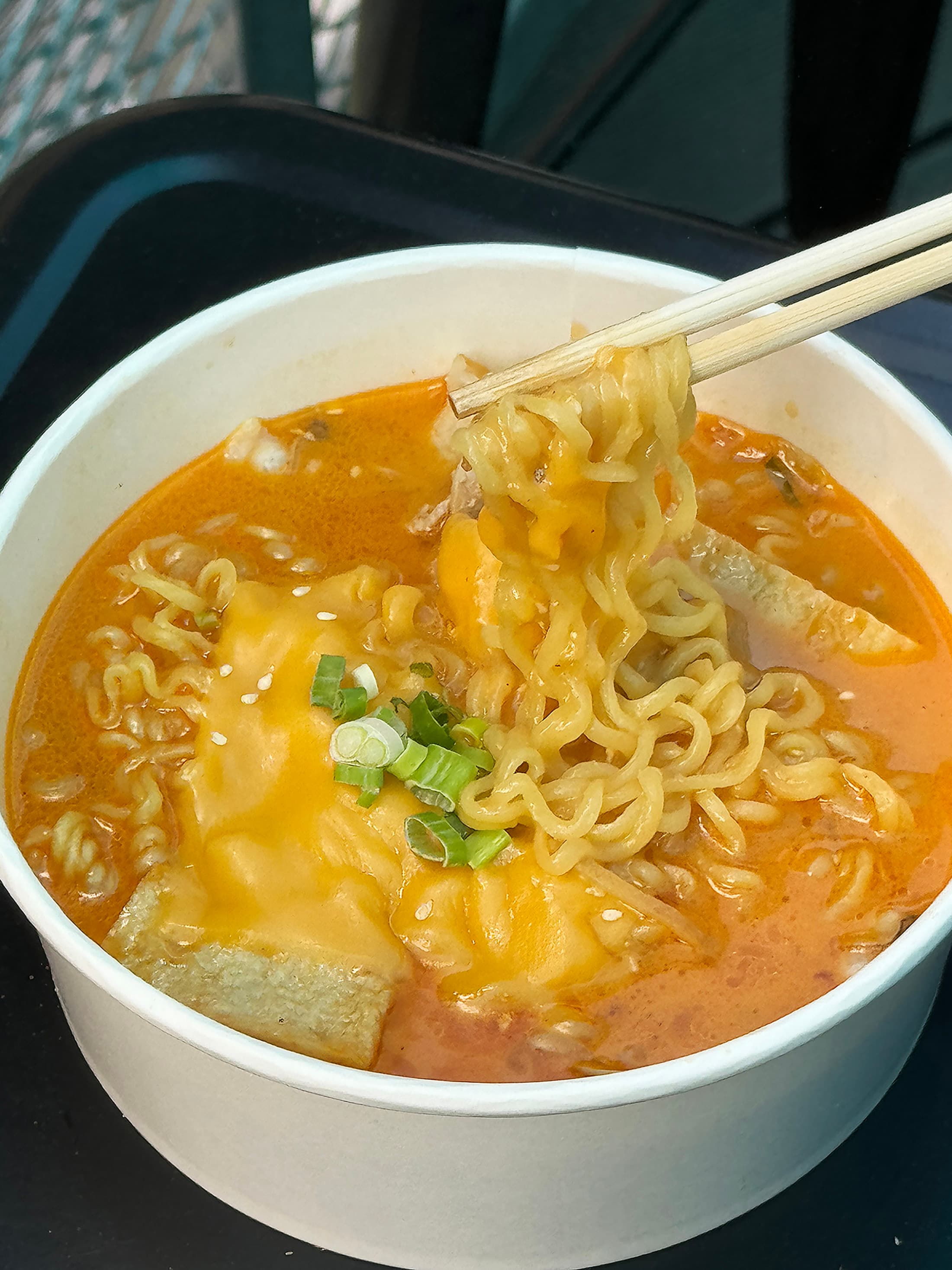 「樂雞起司拉麵」加入魚板、蛤蠣與五花肉等韓國常見食材，為帶有微辣甜感的湯頭增加鮮甜滋味。（180元／份）
