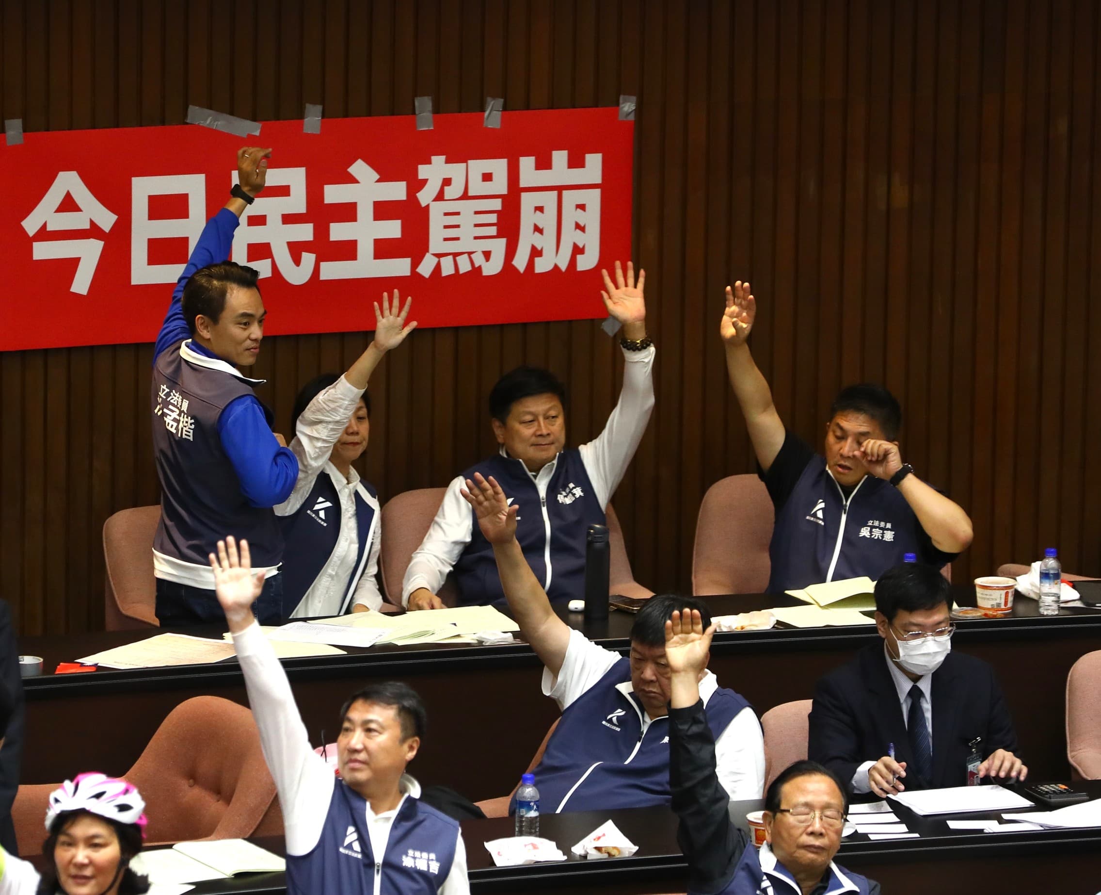 藍委們坐在「今日民主駕崩」的布條前舉手表決。