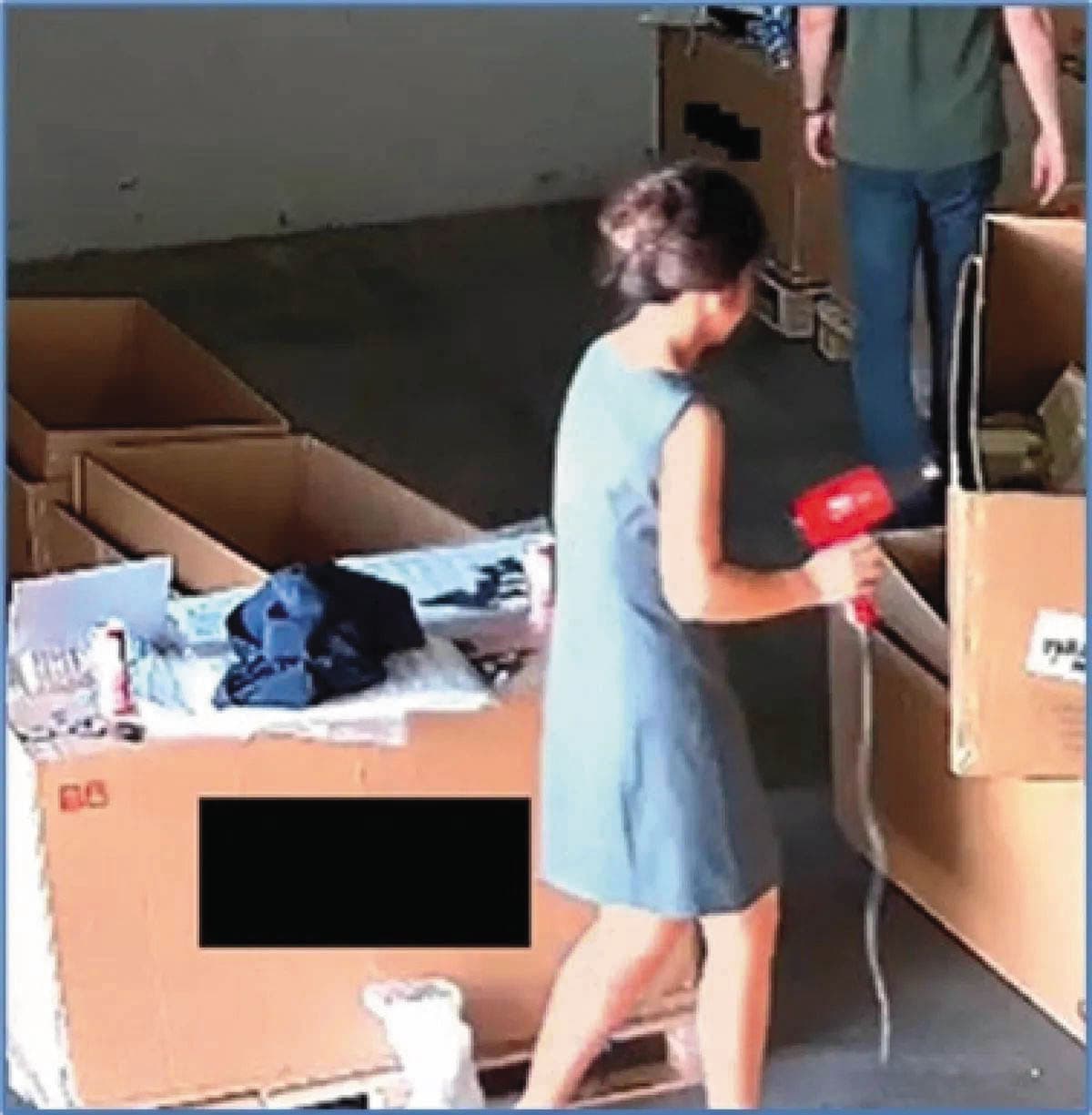 美方根據監視器掌握，不法集團利用吹風機熱風將紙箱標籤改標，盜賣輝達高階晶片至中國謀取暴利。（翻攝美國司法部官網）