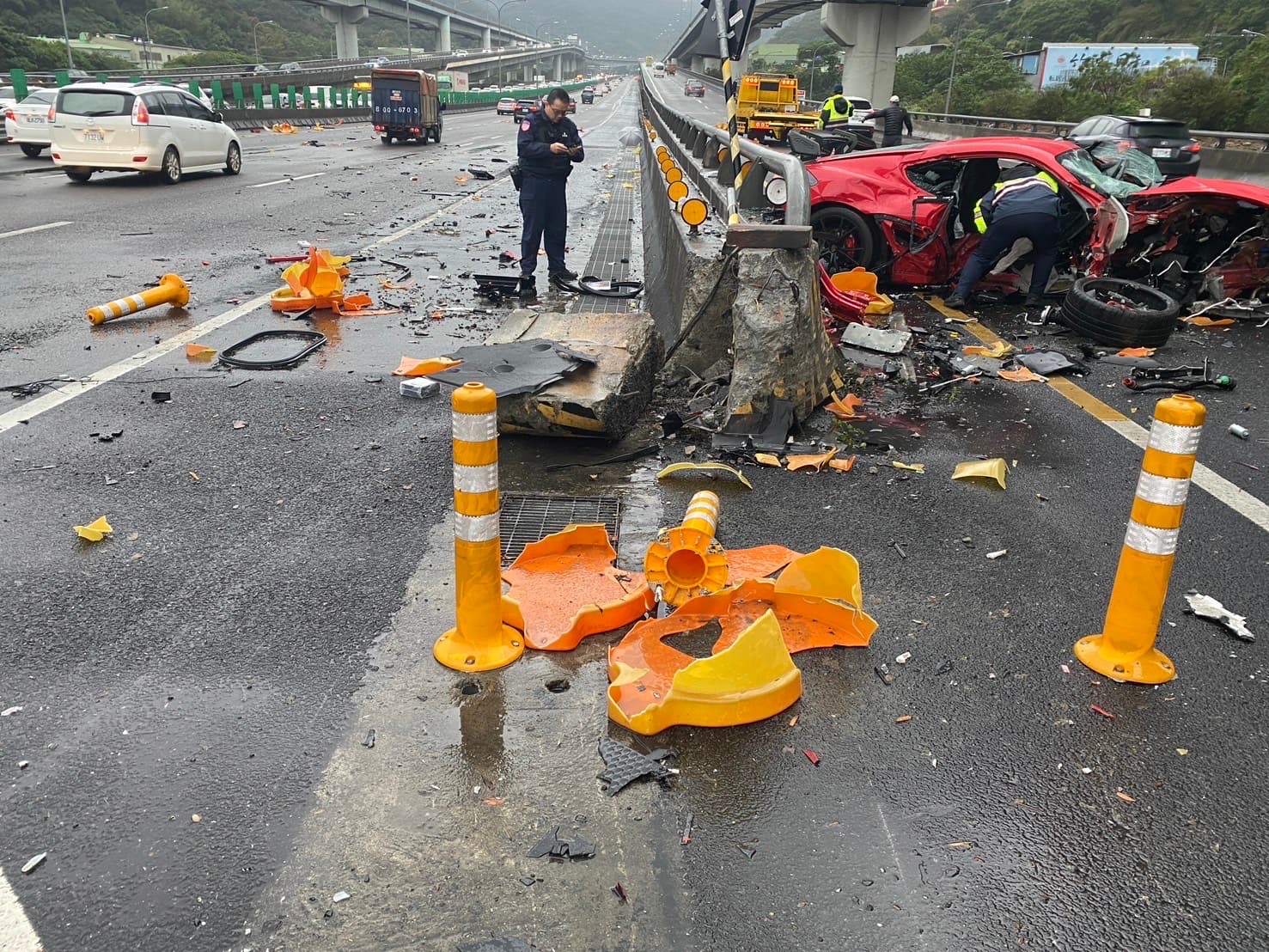 警消將梁男及乘客送往醫院急救；自撞事故造成水泥分隔島也被撞毀。（翻攝畫面）