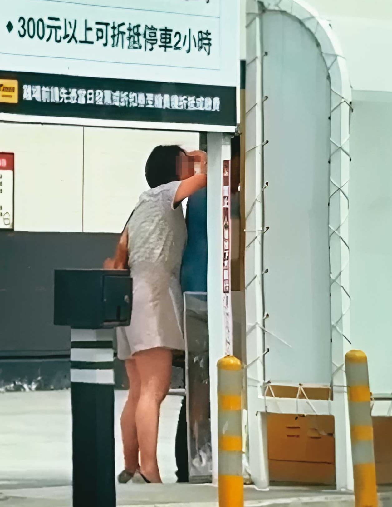 繳停車費時，K女（左）與L男（右）貼得很近，狀似親密。（讀者提供）