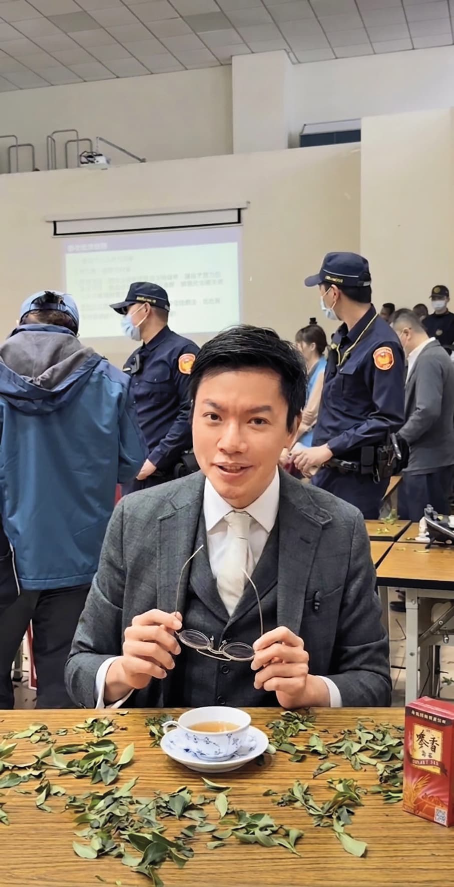 後方是大批警察與抗爭民眾對峙，常行深卻依然淡定喝茶。（翻攝常行深臉書影片截圖）