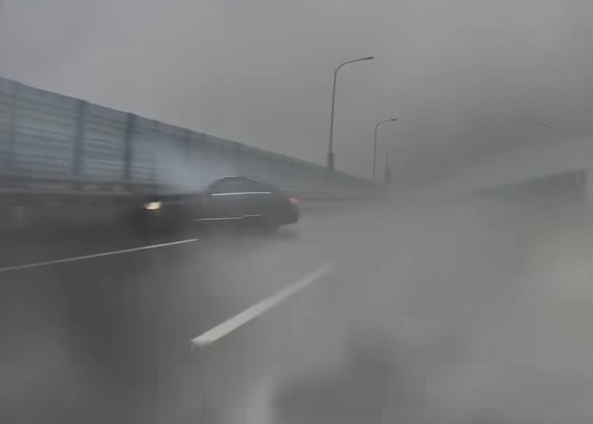 賓士駕駛在發現後車無意「對戰」後似乎自行加速駛離，熟不知一分鐘後，該輛賓士在積水彎道路段打滑失控，自撞外側護欄。（翻攝「爆料公社」）