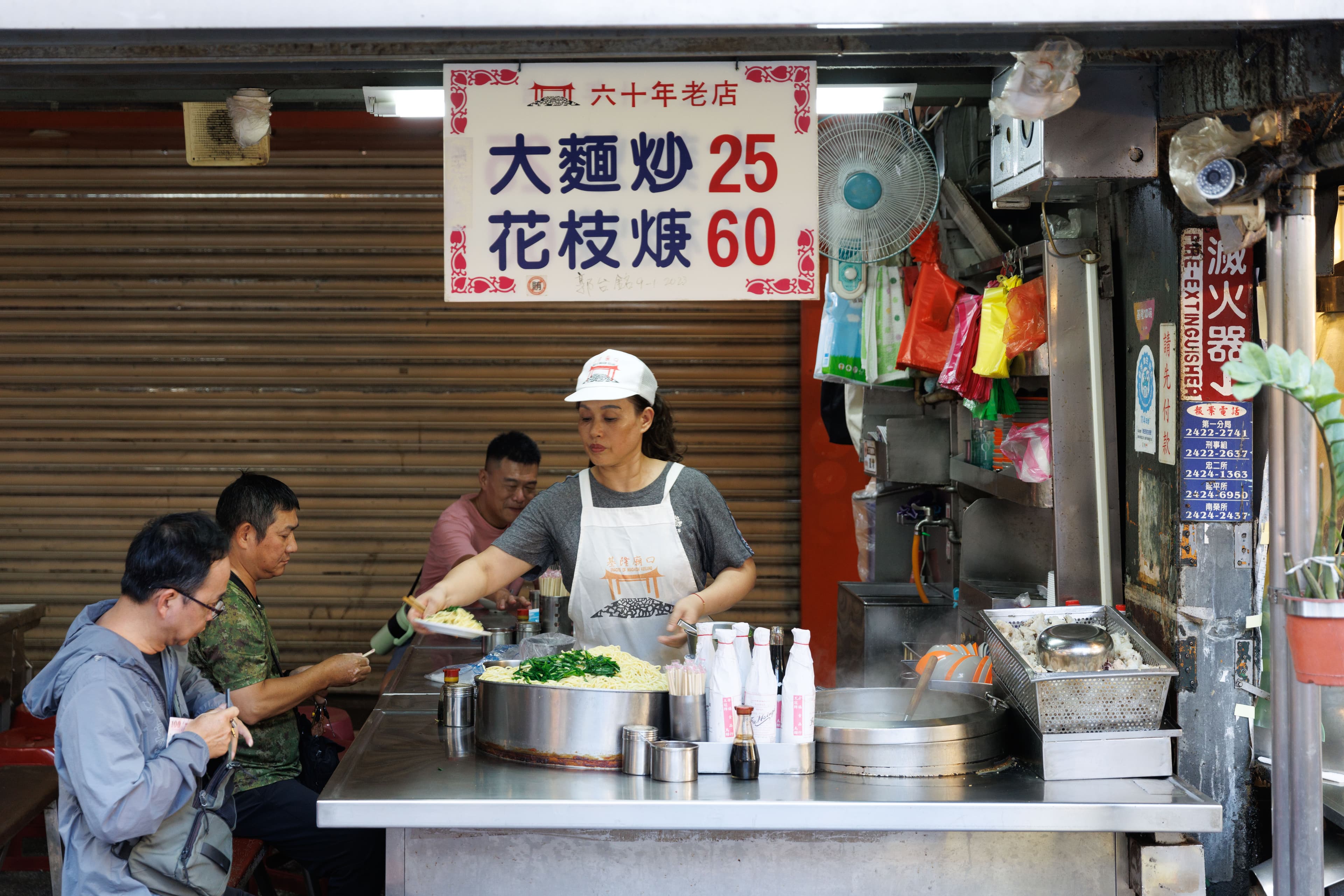 寫著60年老店的「大麵炒、花枝焿」，攤位非常明亮乾淨。