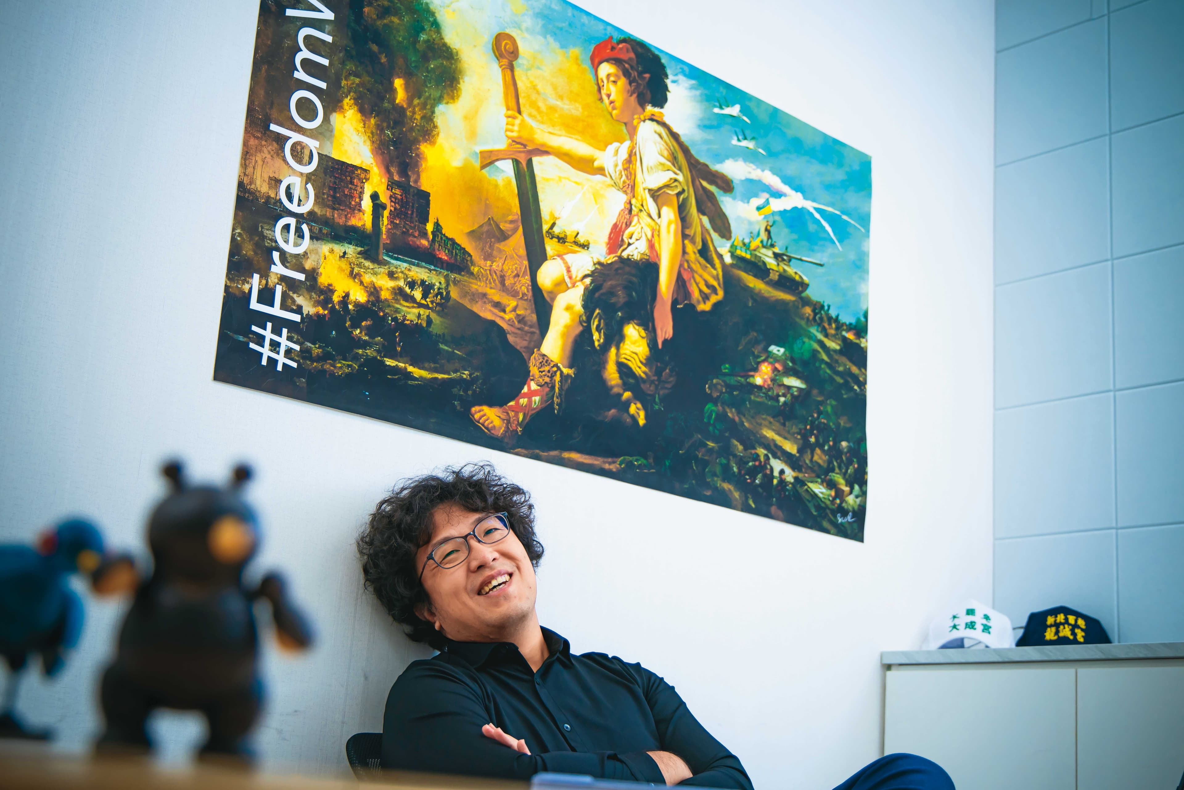 沈伯洋在立法院研究室受訪，辦公室內貼著聲援烏克蘭意象的海報。他一直觀察烏俄戰爭中的虛假訊息與資訊戰。