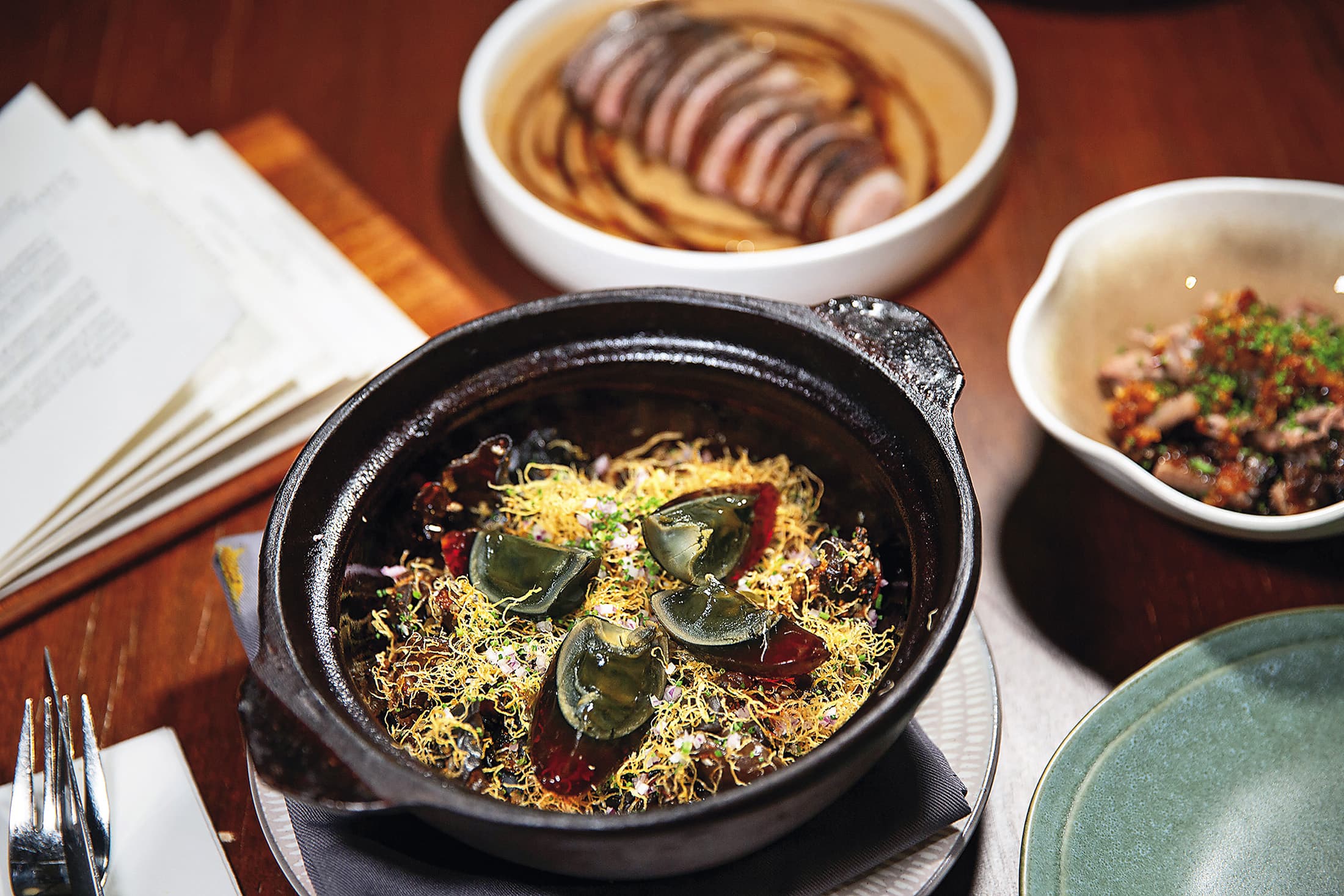 重口味的「皮蛋飯（Century Egg Rice）」（前，馬幣68元／份，約NT$517）與軟嫩「美羅鴨兩吃（Bidor Duck, 2-ways）」（後，馬幣148元／份，約NT$1,125），都是Gēn根的招牌菜。